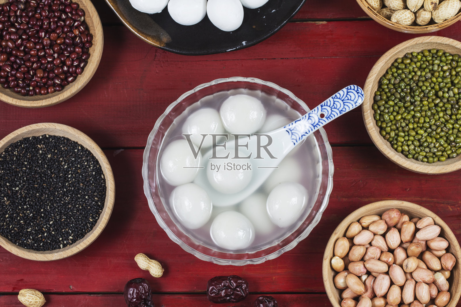 汤圆放在碗里放在桌上，红包和金元宝照片摄影图片