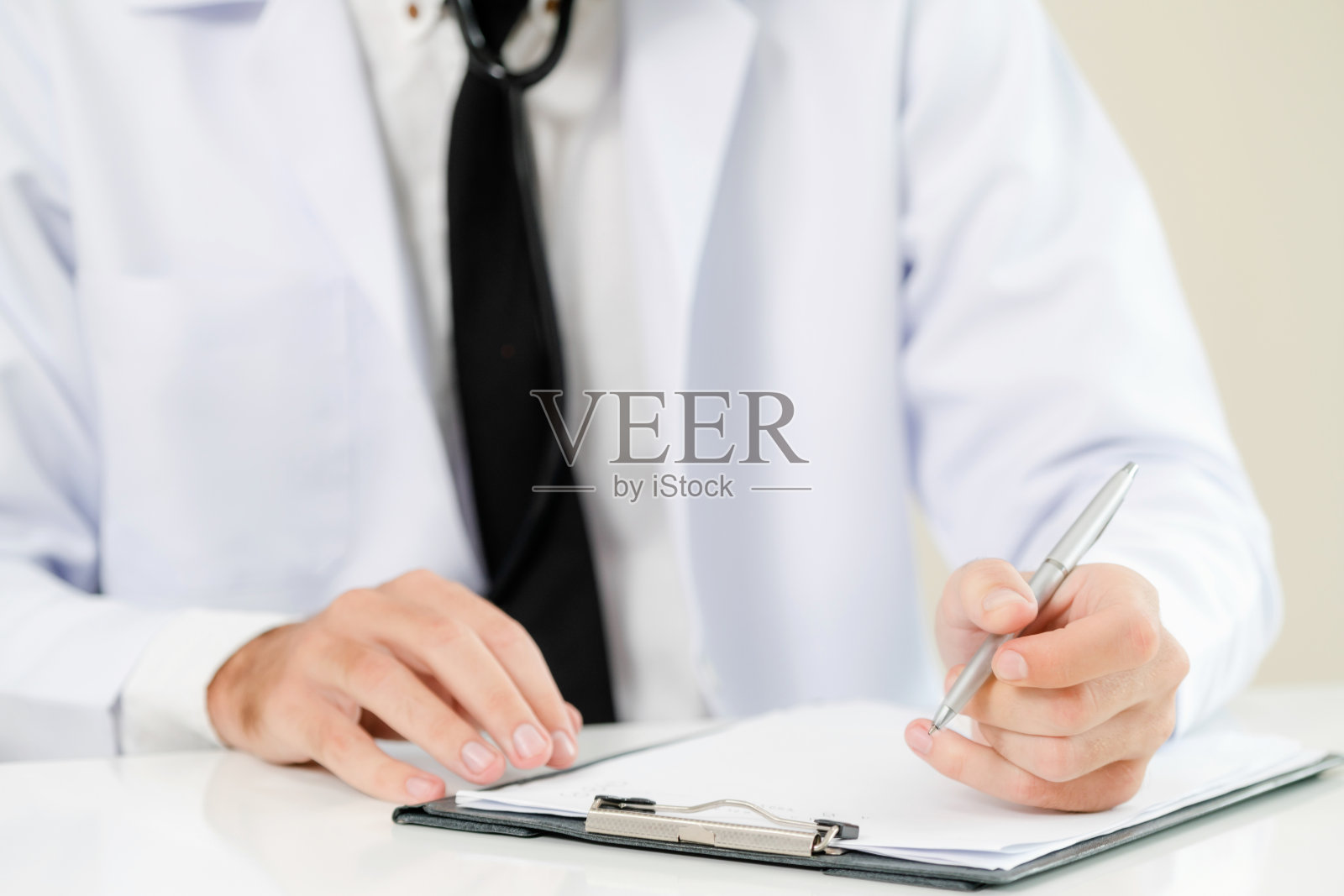 在医院工作并写文书的医生。医疗保健和医疗服务理念。照片摄影图片