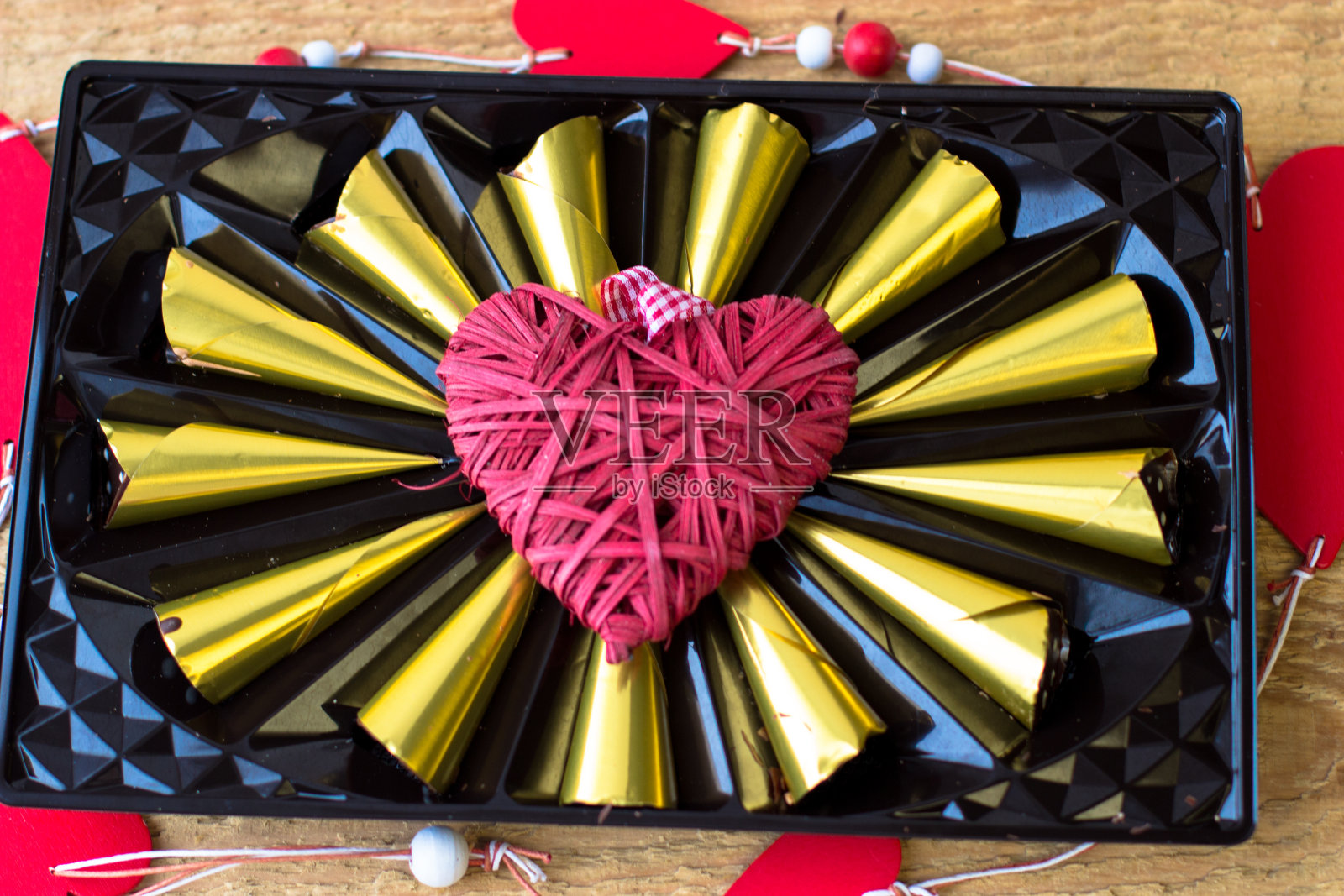 美味的巧克力果仁包裹在金箔心形照片摄影图片