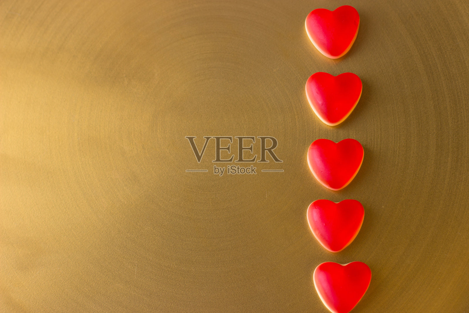 果冻心在金色的金属背景上。情人节的概念。照片摄影图片