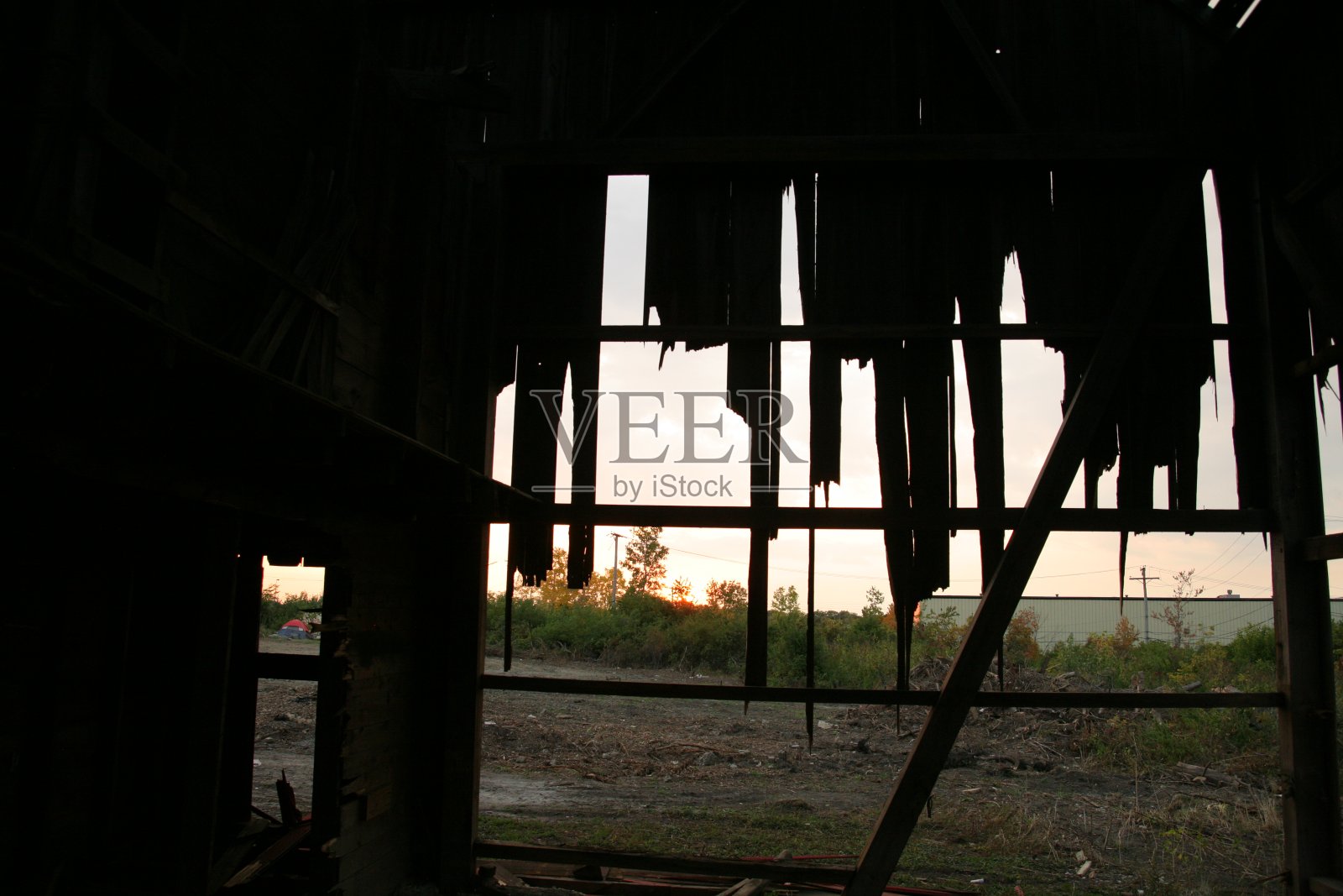 废弃的红色谷仓，风化的木头和日落照片摄影图片