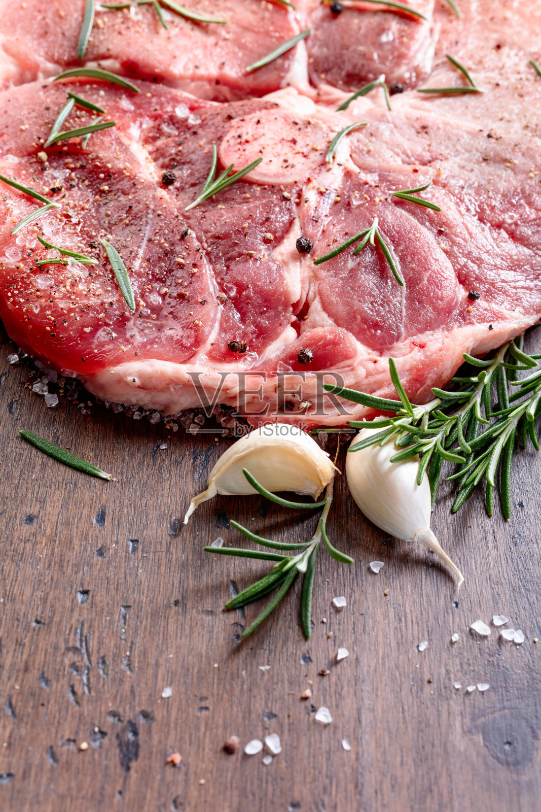 生猪肉加迷迭香，盐和胡椒。照片摄影图片