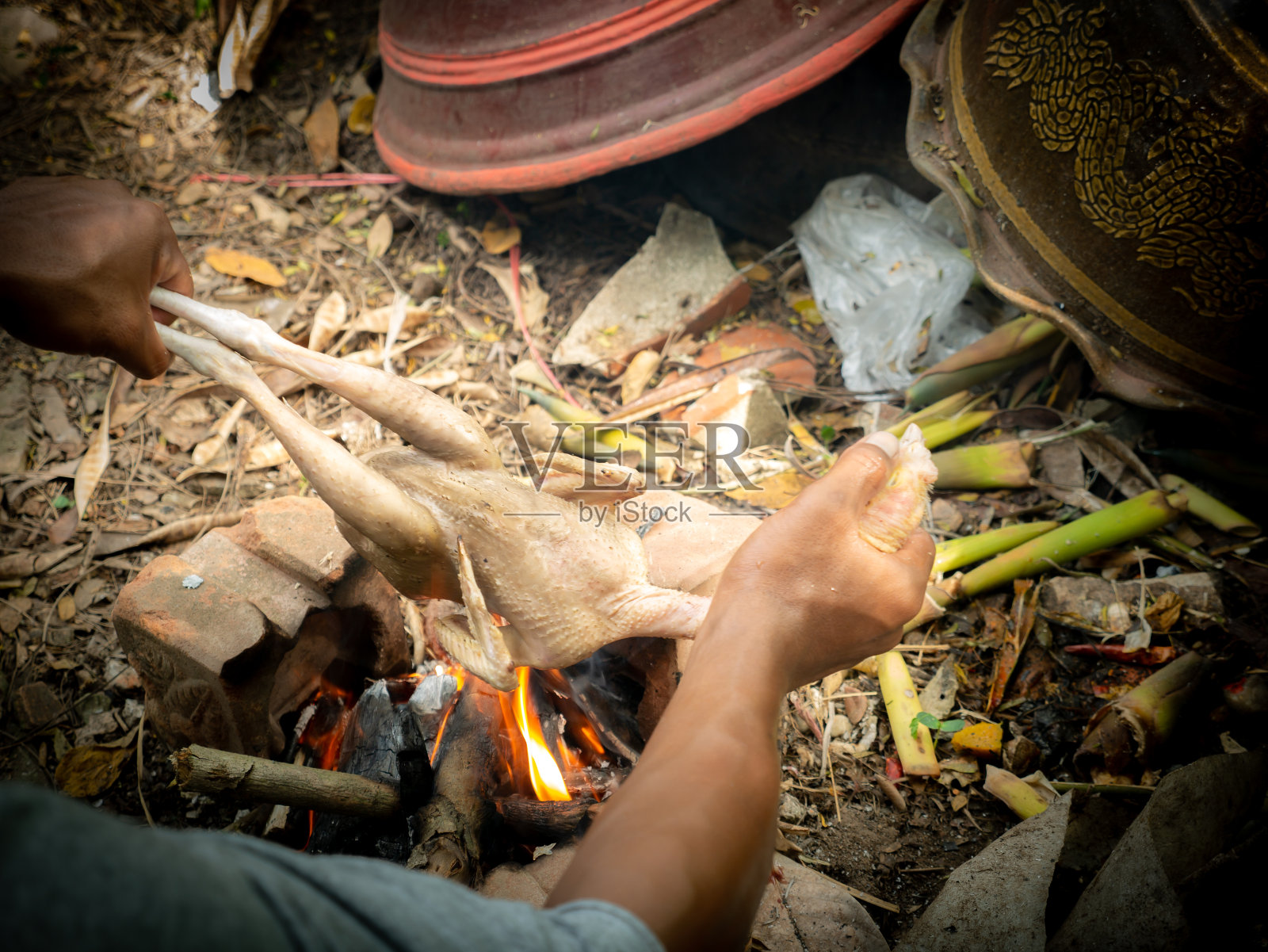 农夫徒手烤鸡吃照片摄影图片