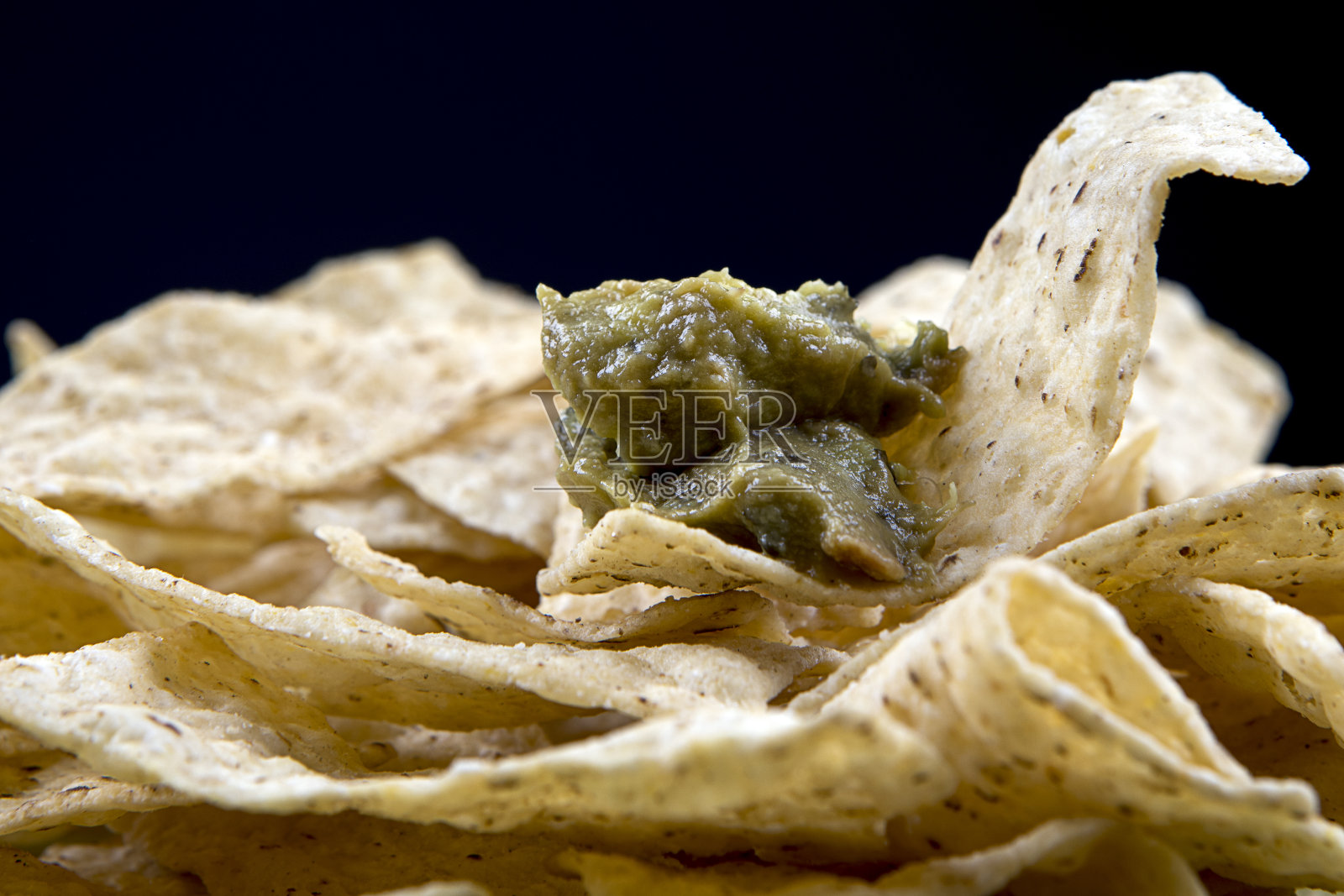 墨西哥玉米片上的鳄梨酱。照片摄影图片