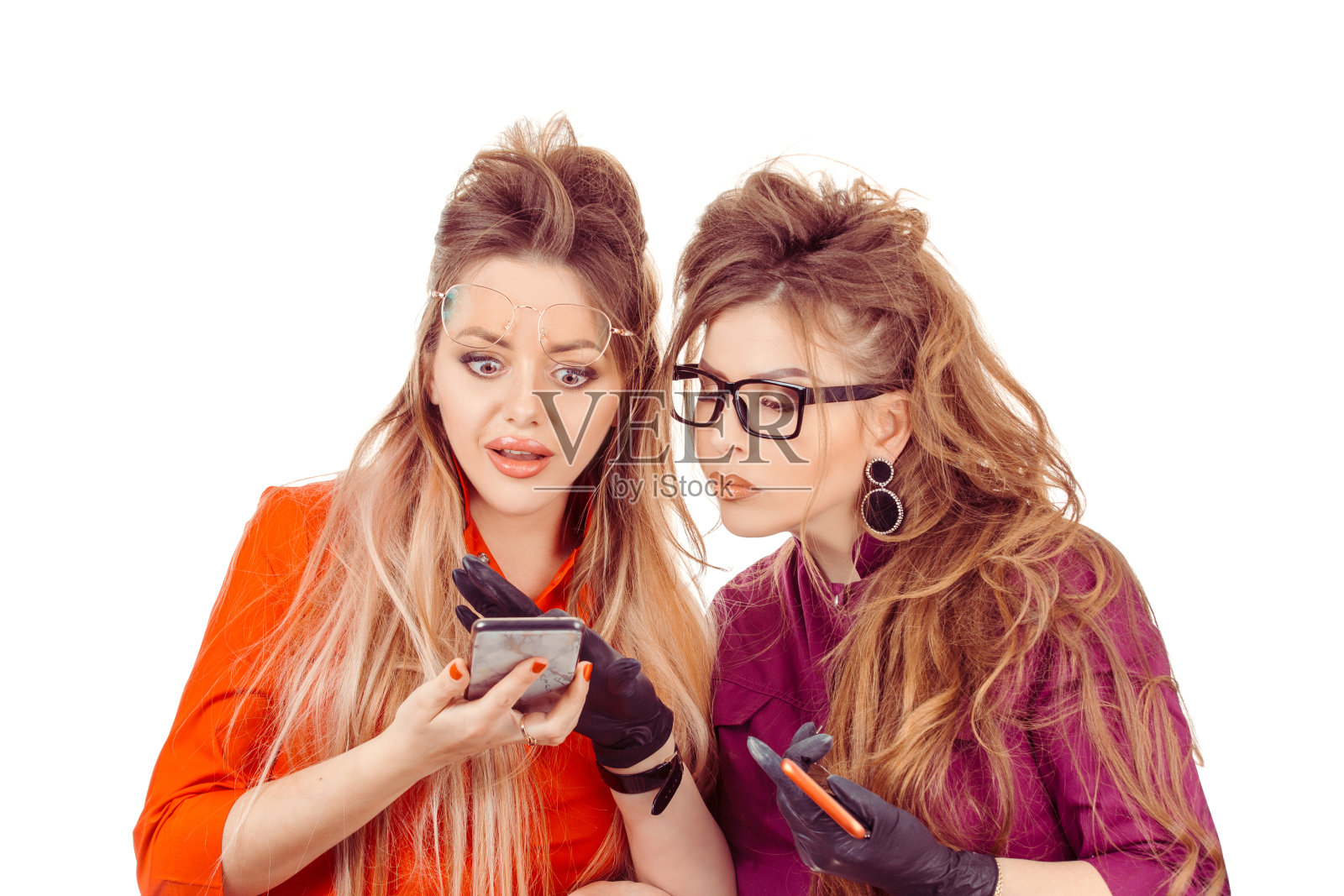 两个震惊的妇女年轻女孩看着手机看到令人震惊的消息或照片与惊讶的情绪照片摄影图片