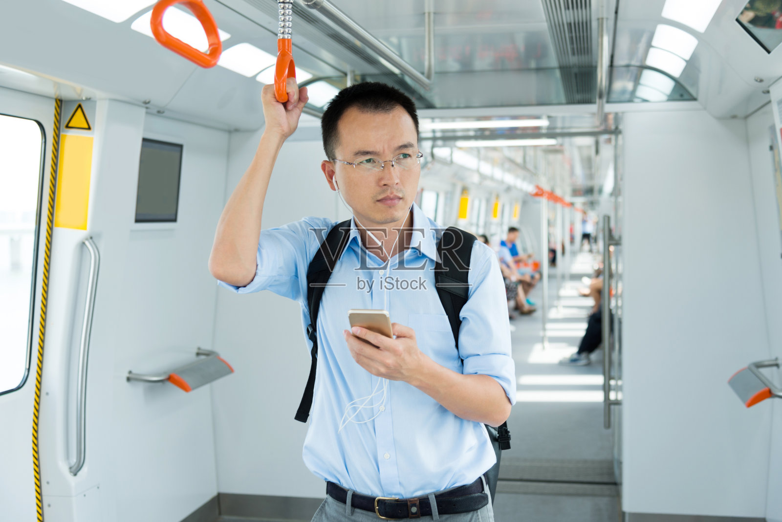 商人在地铁里听音乐照片摄影图片