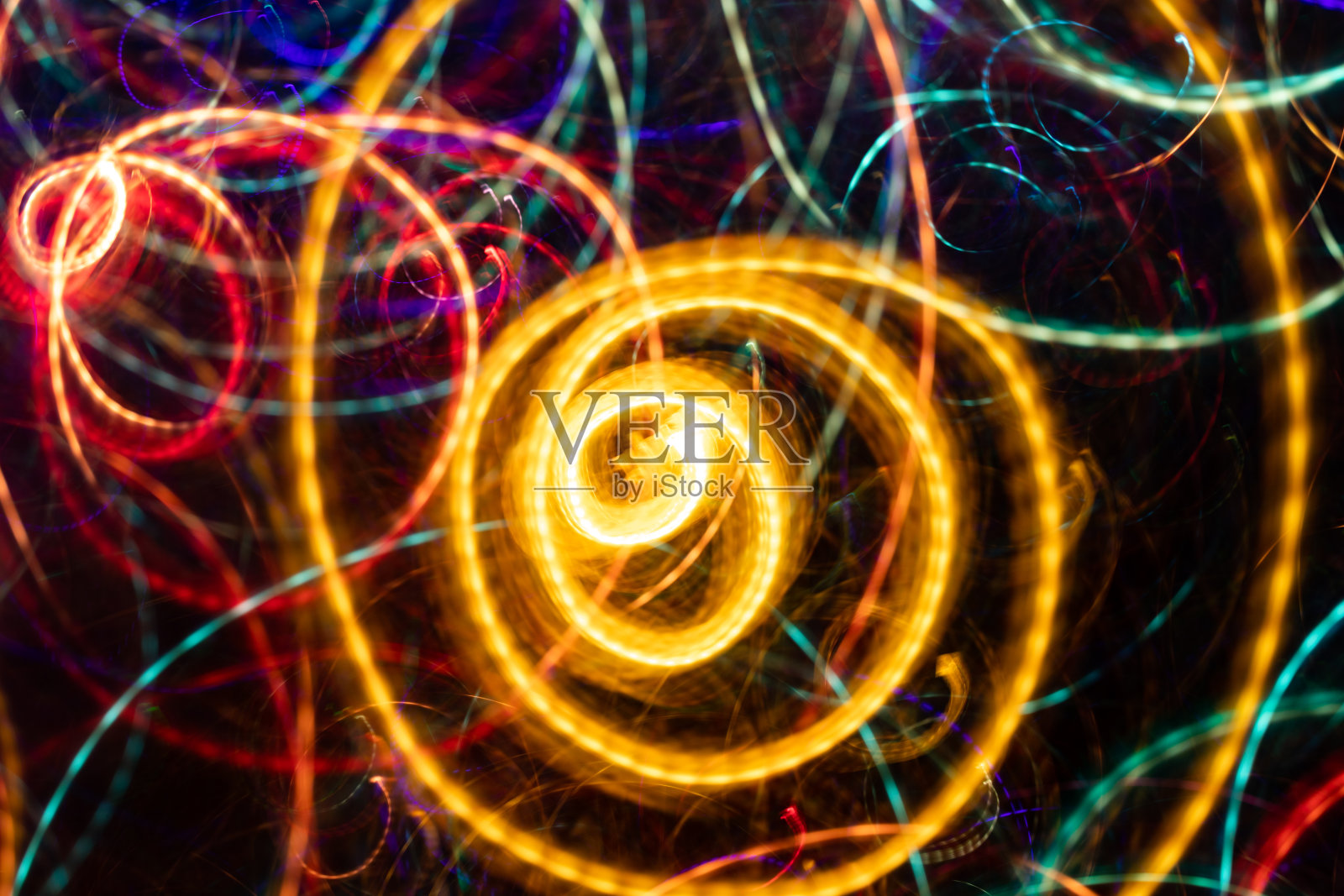 特写抽象发光的黄色螺旋漩涡在黑色的背景。照片摄影图片