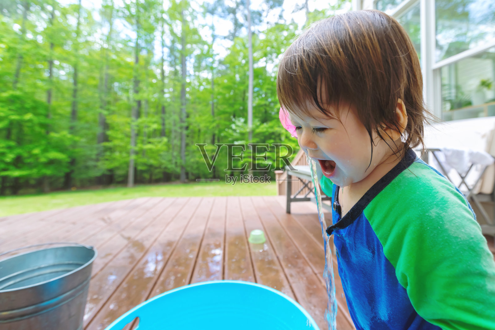 蹒跚学步的小男孩在玩水照片摄影图片