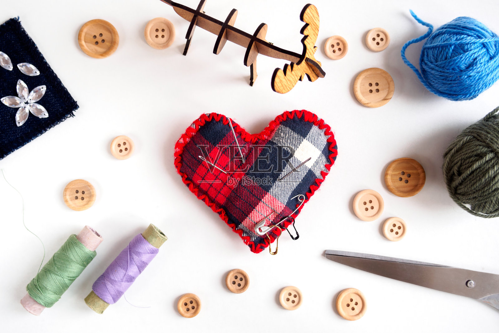 裁缝店的针线、剪刀、纽扣和针枕的俯视图，在白色的背景上，平铺照片摄影图片