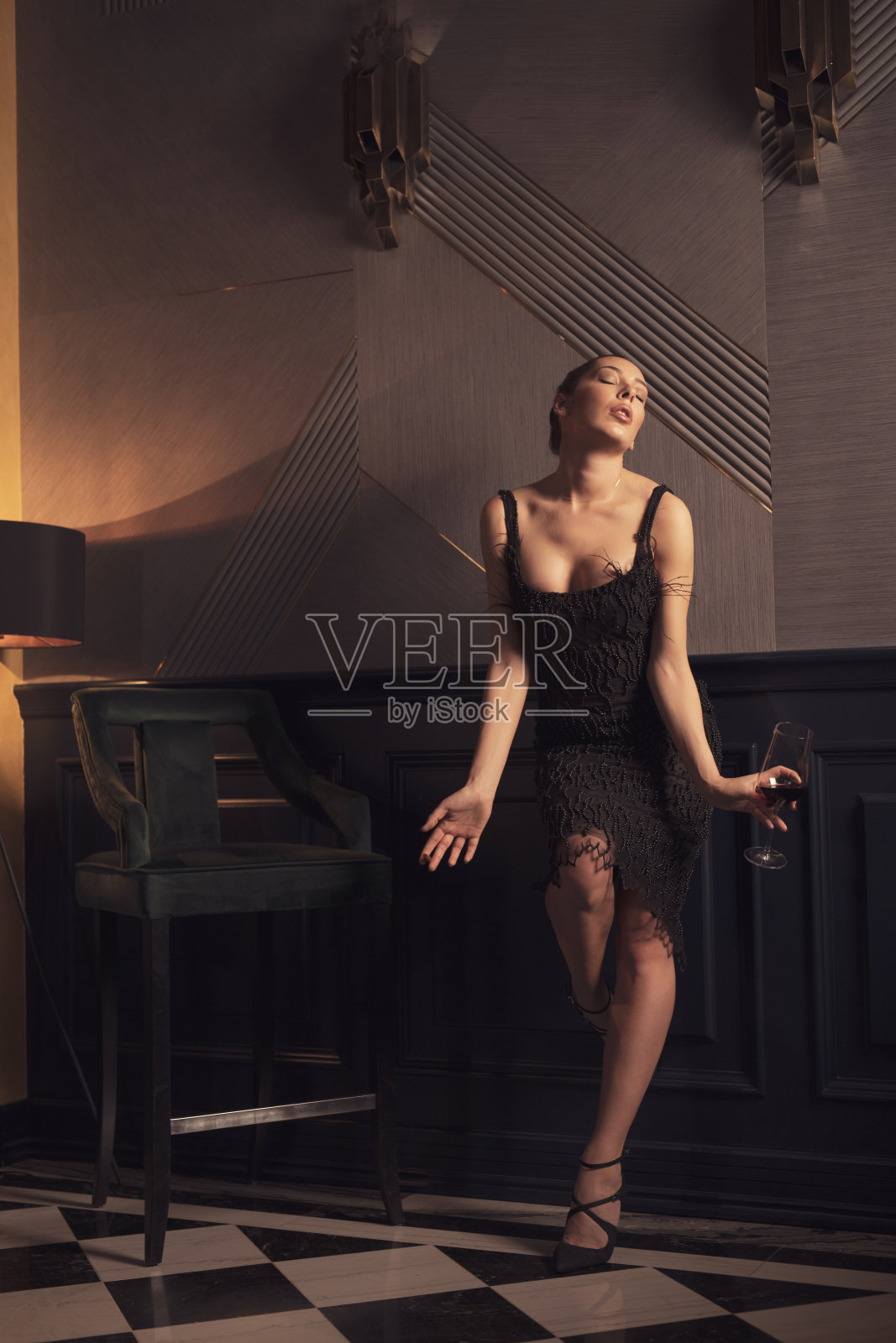 美女喝红酒。时尚写真，年轻女子衣着优雅生活方式。在一个豪华的内部。照片摄影图片