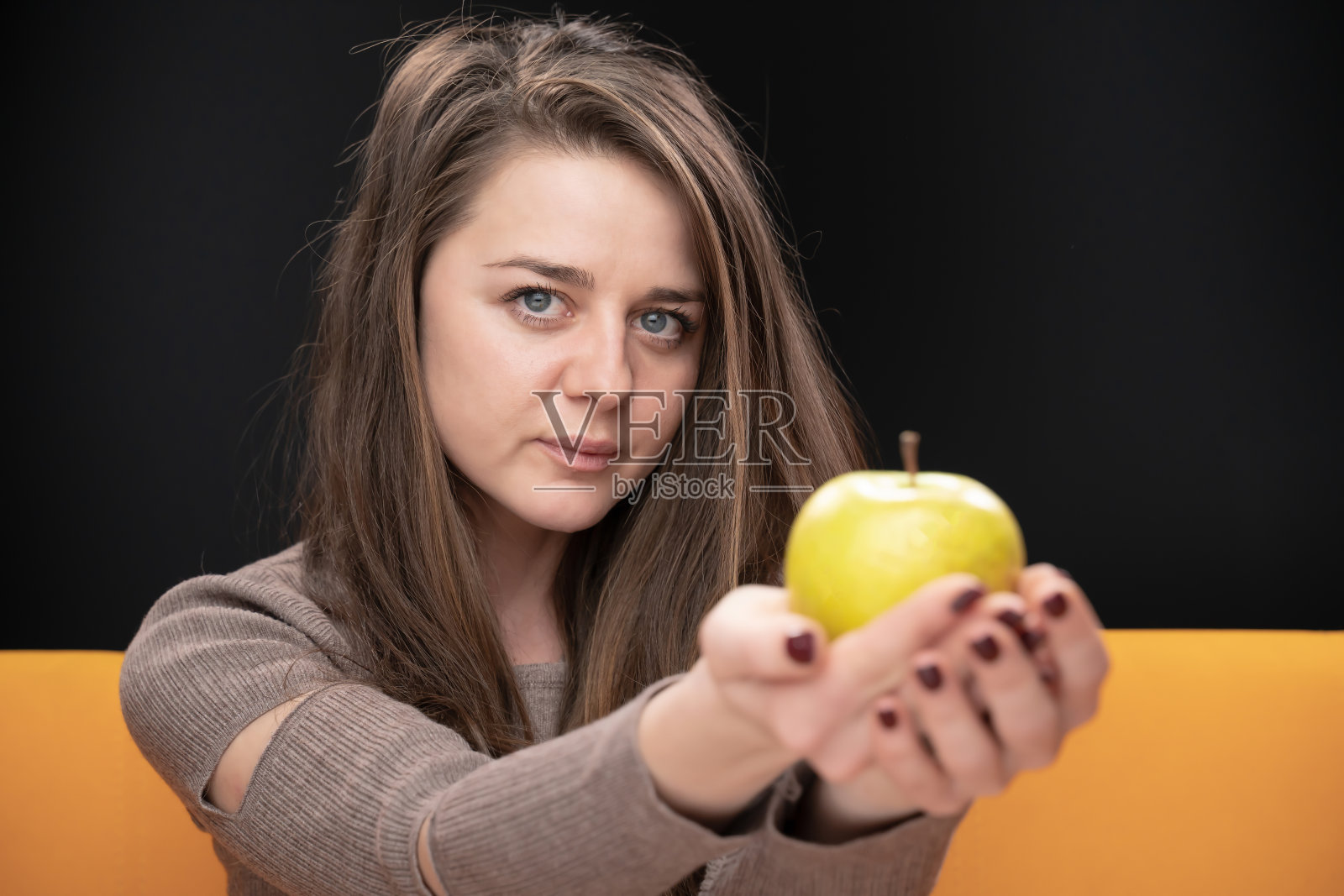 女孩拿着青苹果看镜头照片摄影图片