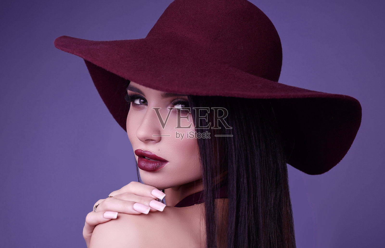 优雅美丽的黑发女子，紫色的衣服和宽帽子照片摄影图片
