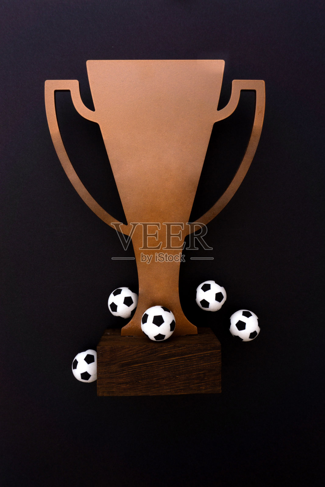 黑色背景上有球的足球杯。照片摄影图片