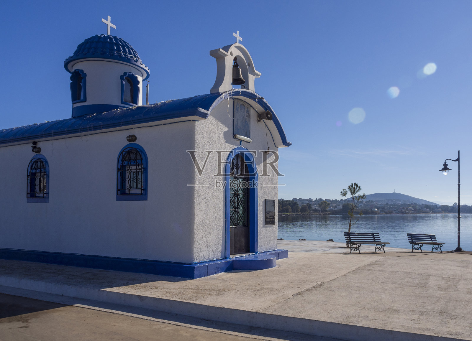 在一个阳光明媚的日子里，在希腊埃维亚岛的蓝天下，美丽的蓝色和白色的希腊教堂照片摄影图片