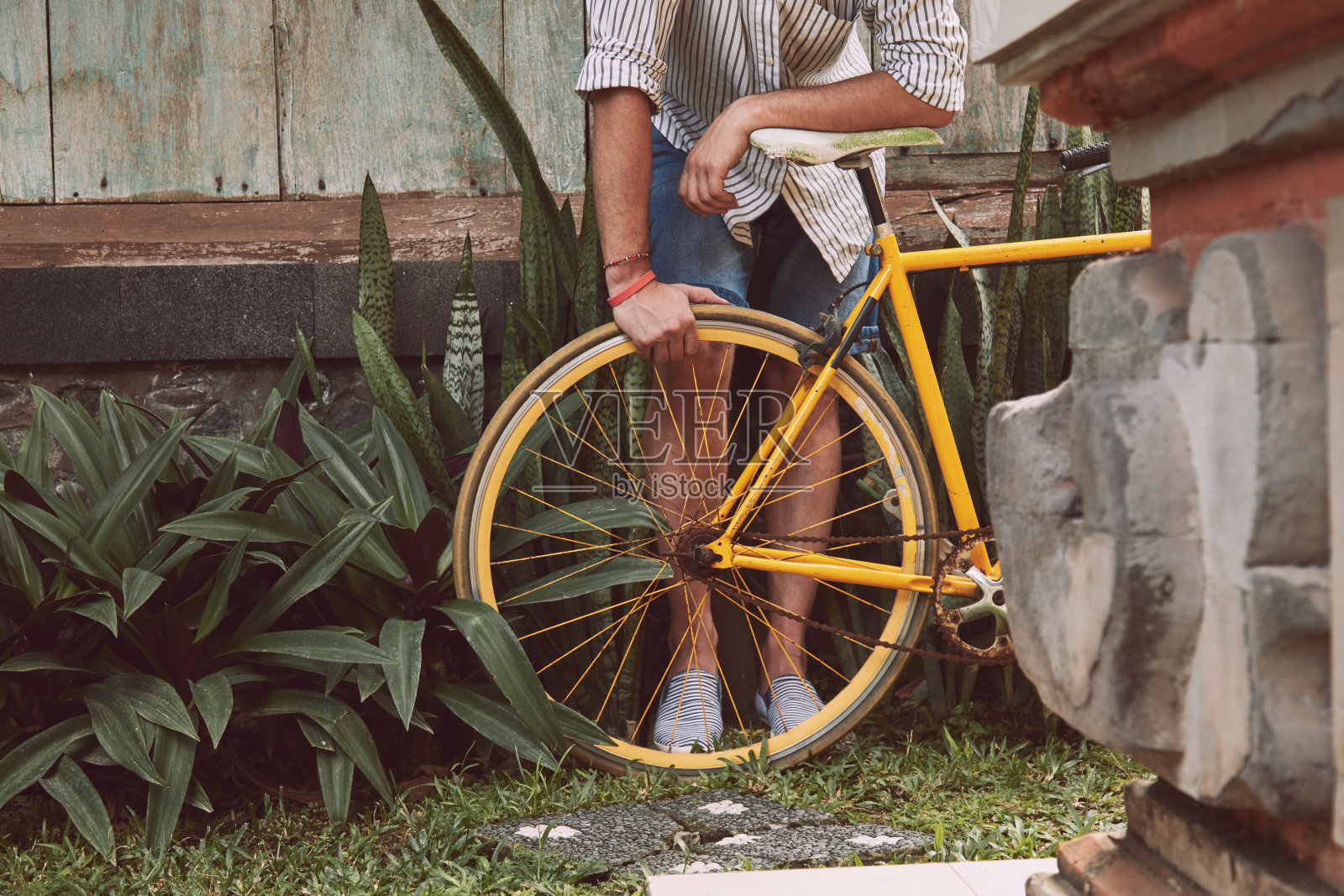 有魅力的男人站在旧自行车。照片摄影图片