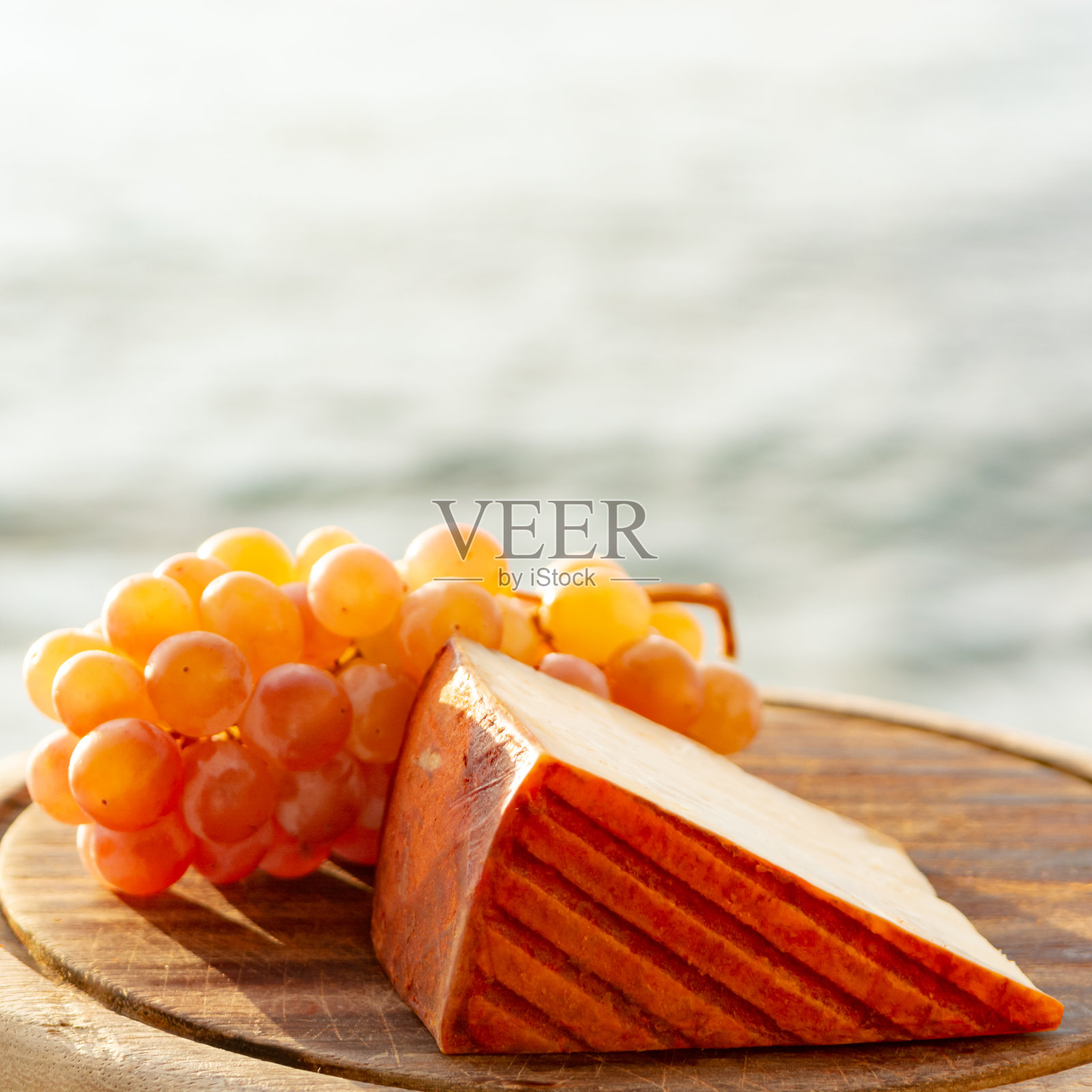 西班牙山羊奶奶酪配上红辣椒和成熟的粉红葡萄照片摄影图片