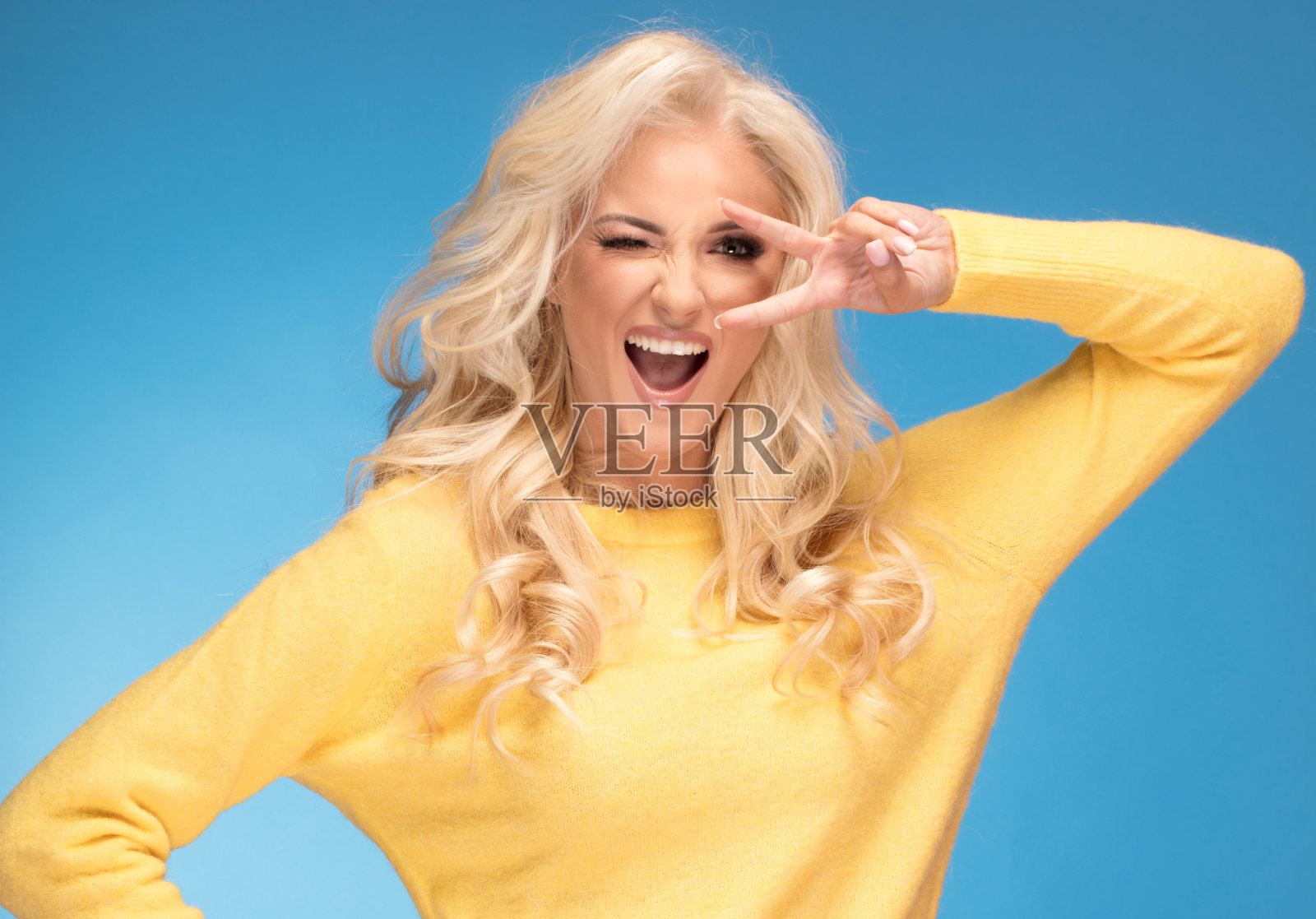 穿着黄色毛衣的金发女孩。照片摄影图片