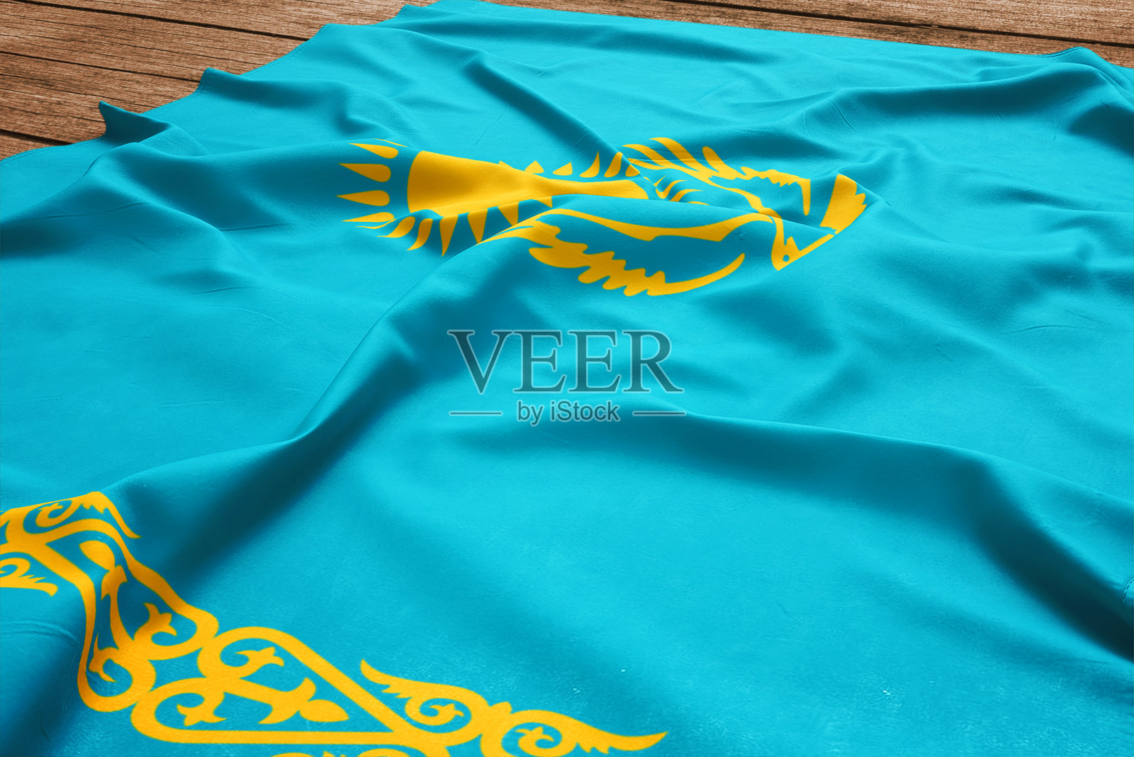 木桌背景上的哈萨克斯坦国旗。丝绸哈萨克旗顶视图。照片摄影图片