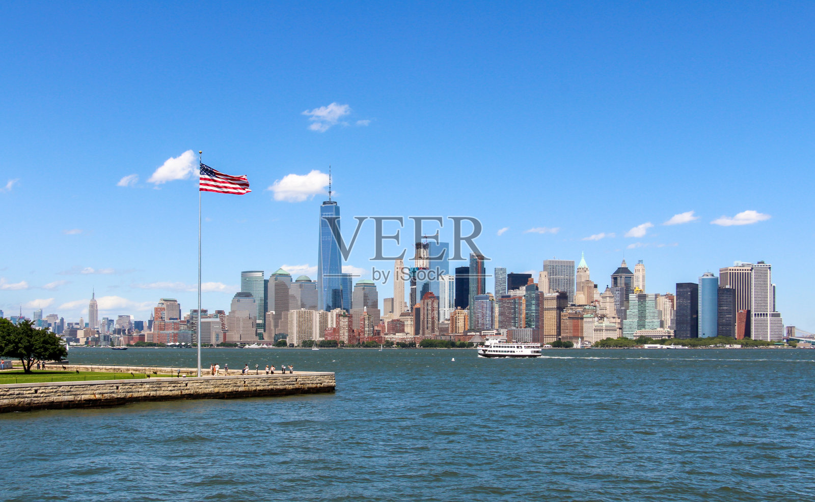 从埃利斯岛眺望纽约的天际线，展示着美国国旗照片摄影图片