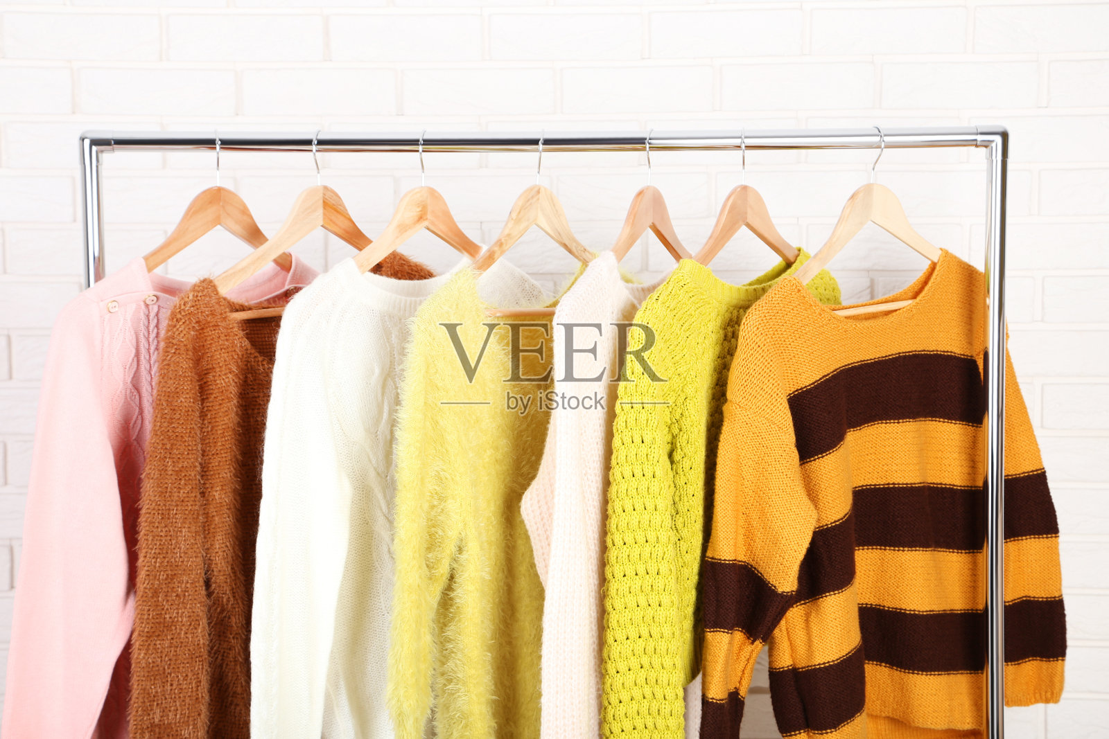 砖墙背景上挂着时尚毛衣照片摄影图片