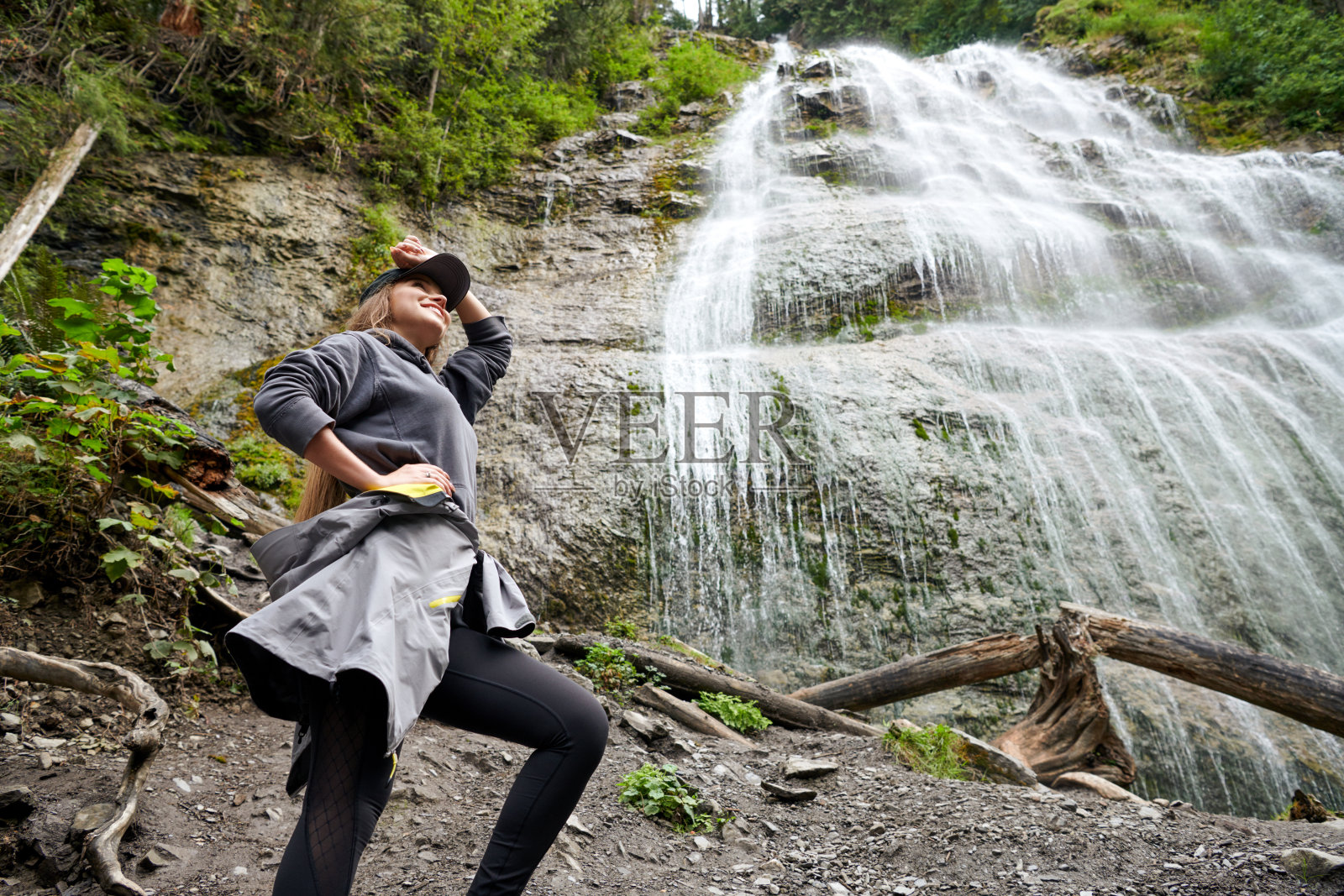 年轻漂亮的女人在瀑布附近徒步旅行照片摄影图片