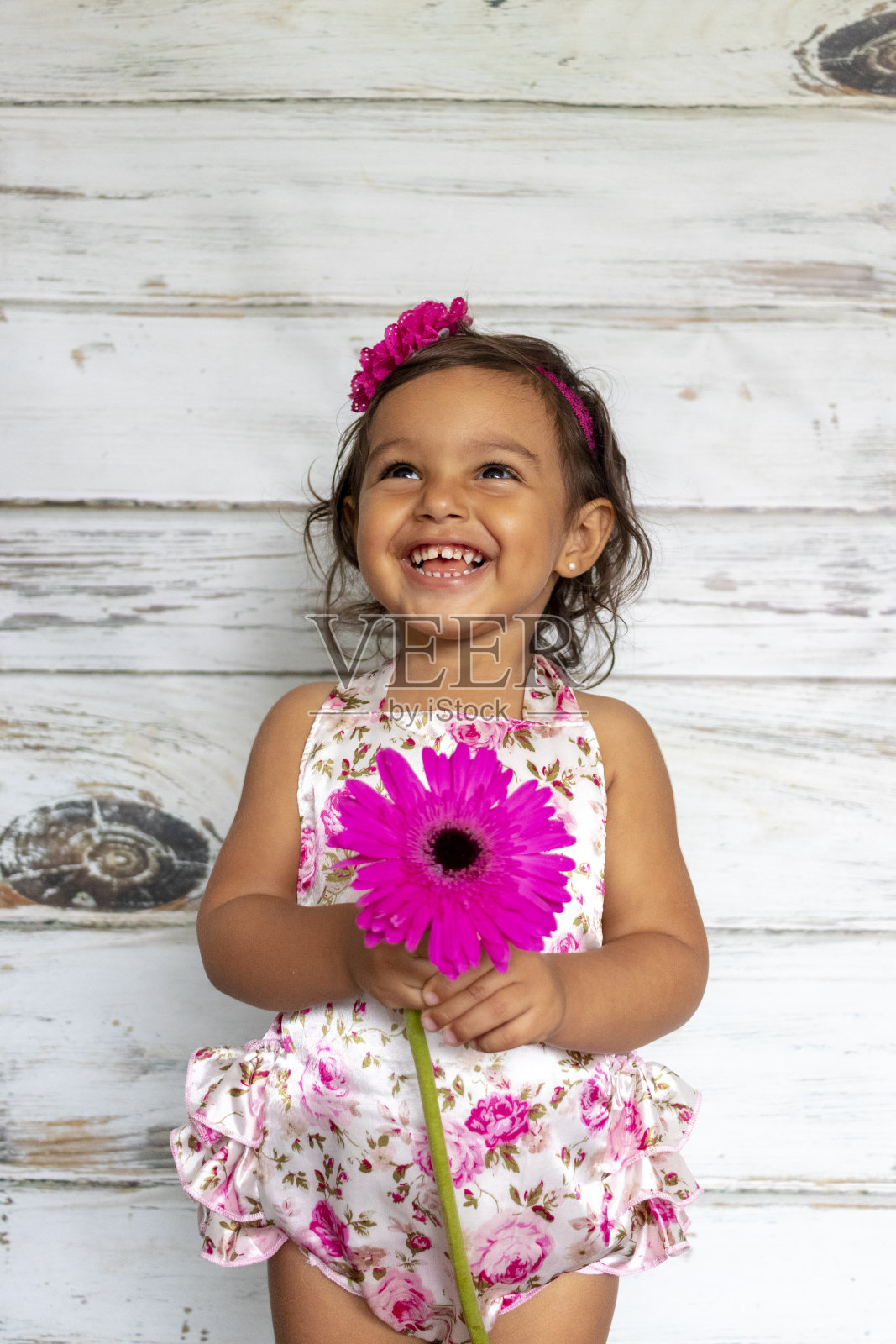 稚嫩微笑的幼儿，手里拿着一朵花照片摄影图片