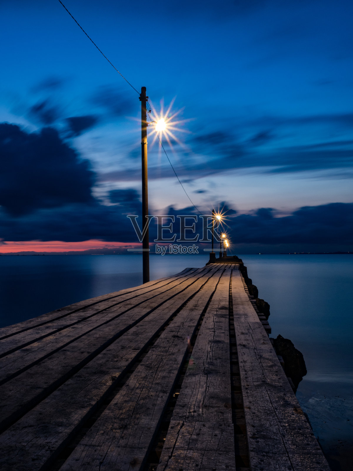 日落后的木码头。照片摄影图片