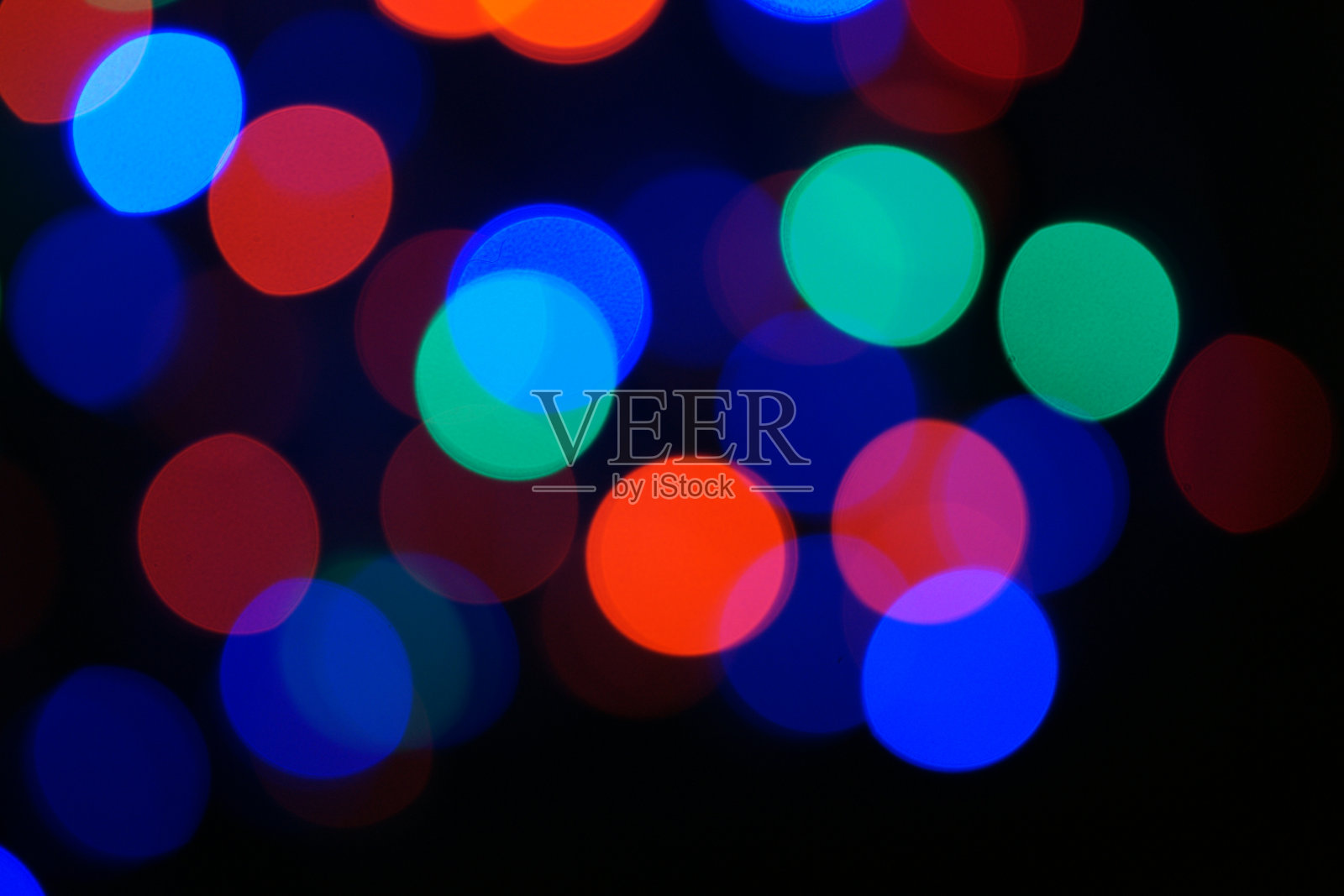 多色蓝色节日花环。花环是模糊的。许多五颜六色的大圆灯。完全散焦照片。模糊的背景和前景。节日的心情。新年和圣诞节即将来临。照片摄影图片