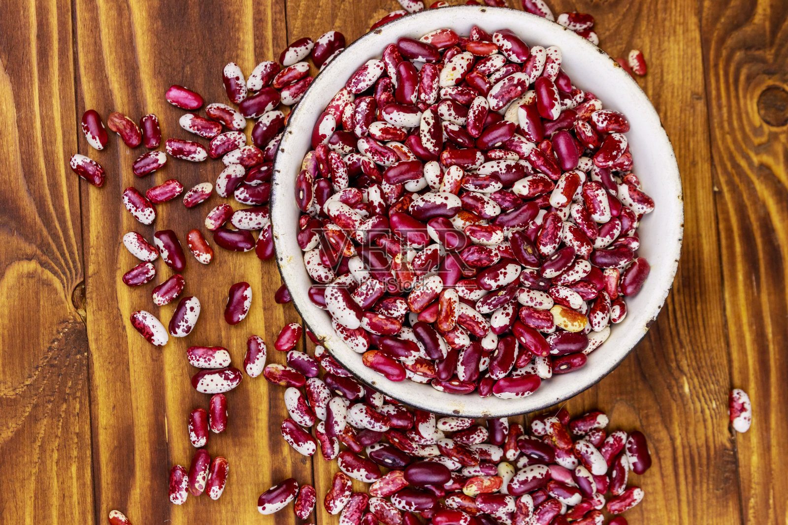 木桌上的白色搪瓷碗里盛着生芸豆照片摄影图片