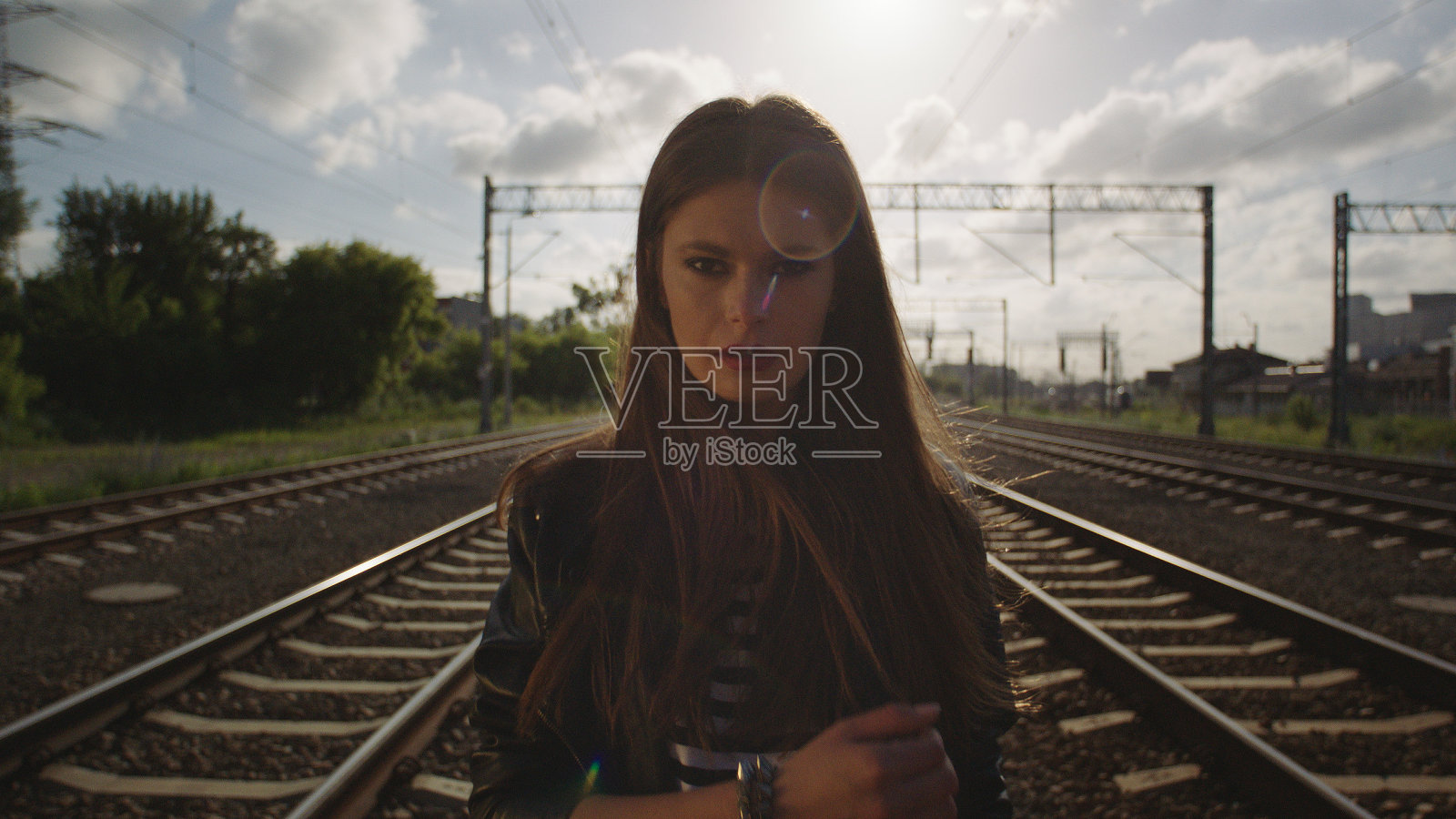 诱惑的女人走在铁路上。看相机。摇滚风格。照片摄影图片