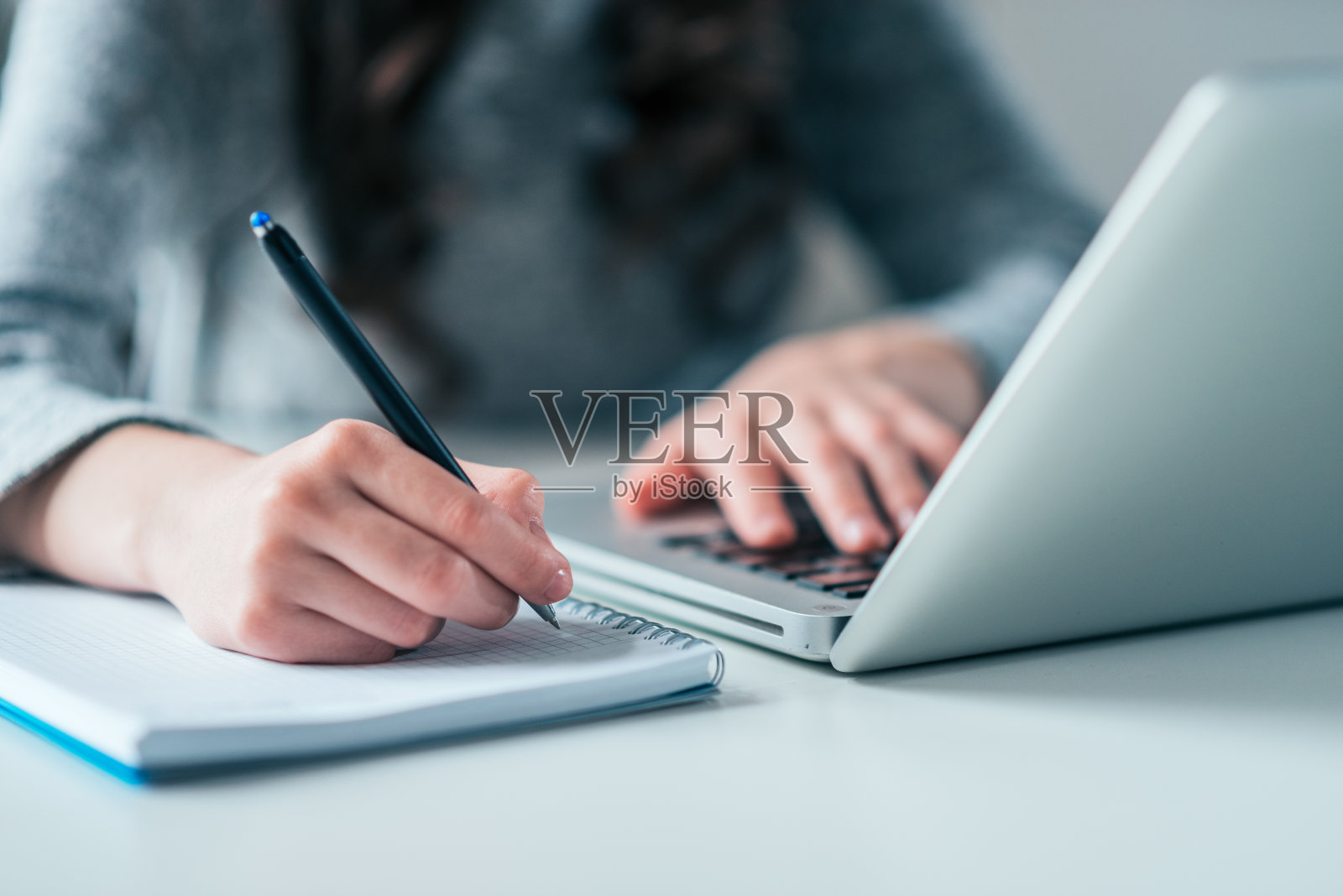 商业教育理念。使用笔记本电脑，在笔记本上写字。照片摄影图片