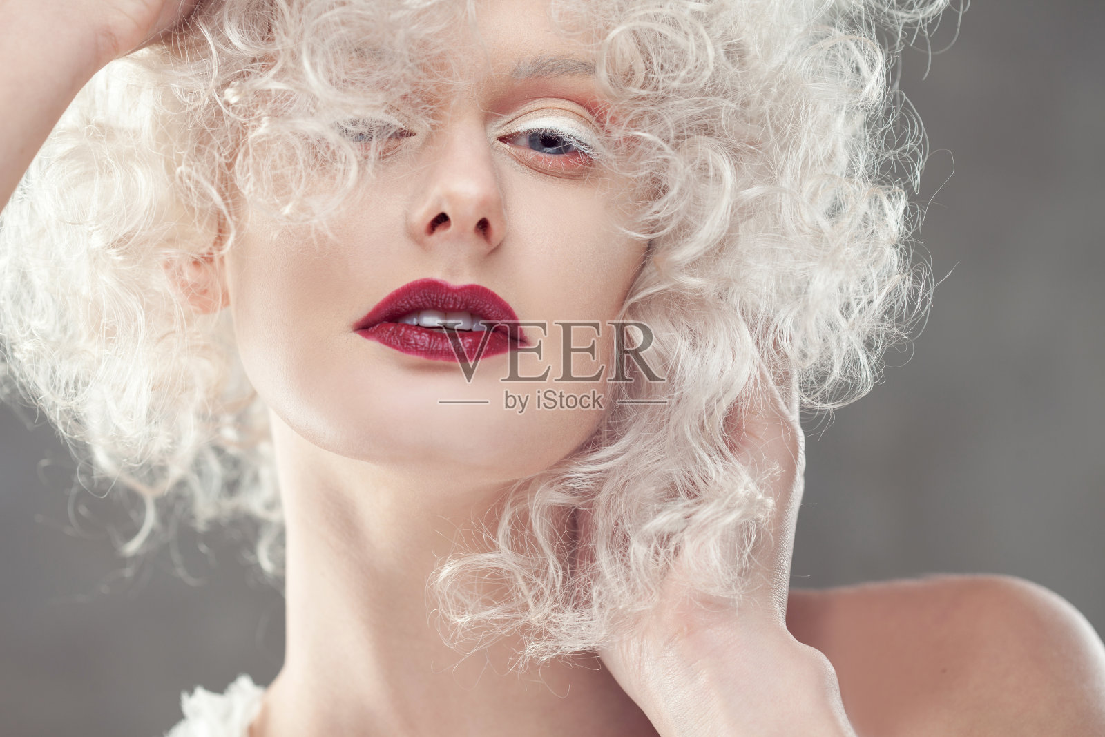 年轻迷人的女人，涂着淡金色的紫色口红照片摄影图片