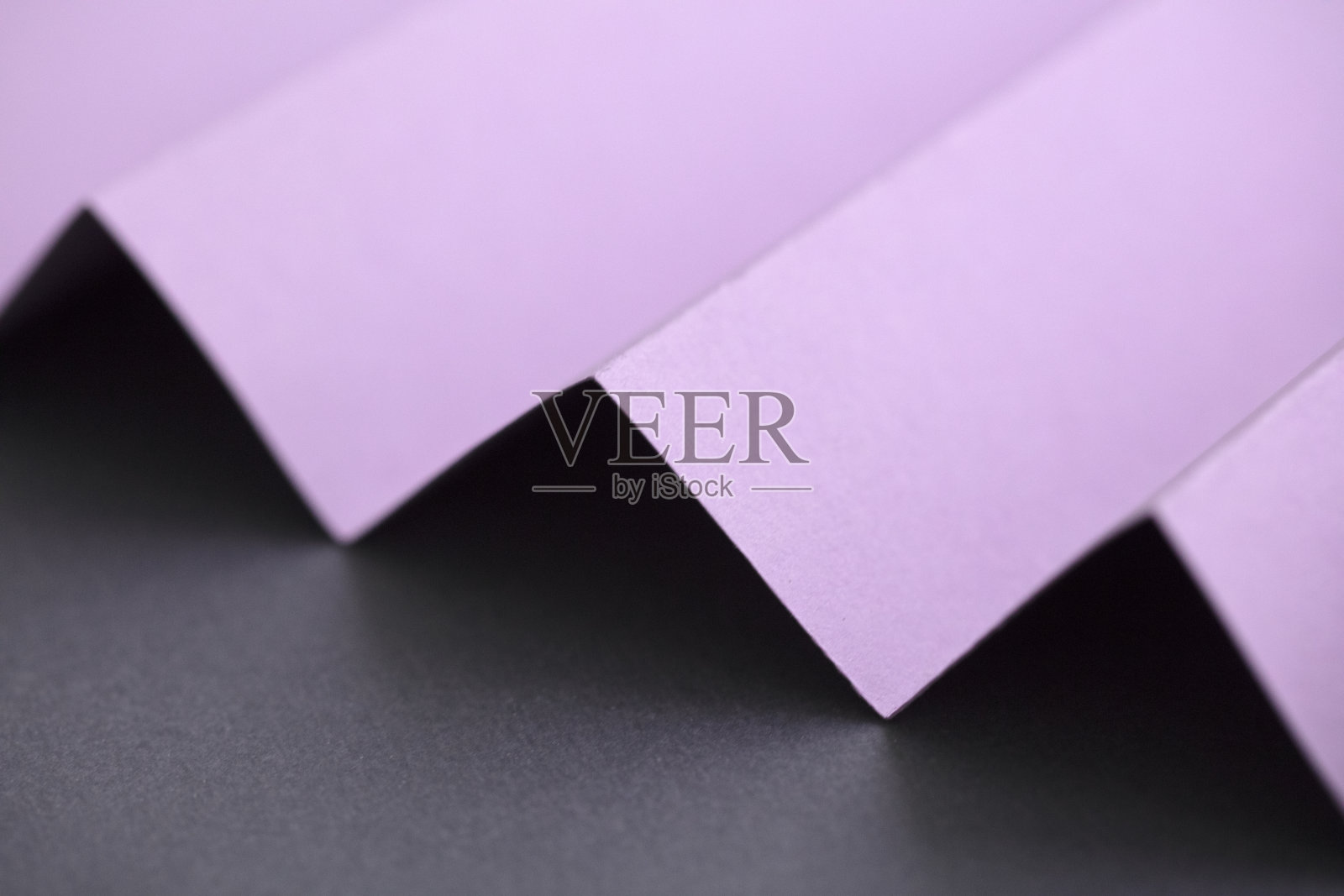 灰色背景上的粉色对角线折叠纸照片摄影图片