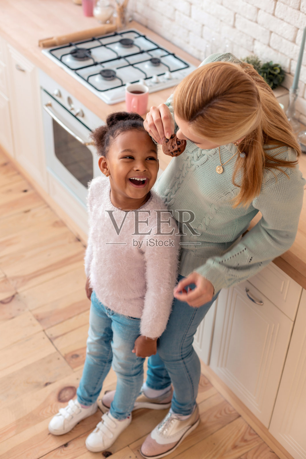 俯视图母亲和女儿尝试他们自制的饼干照片摄影图片