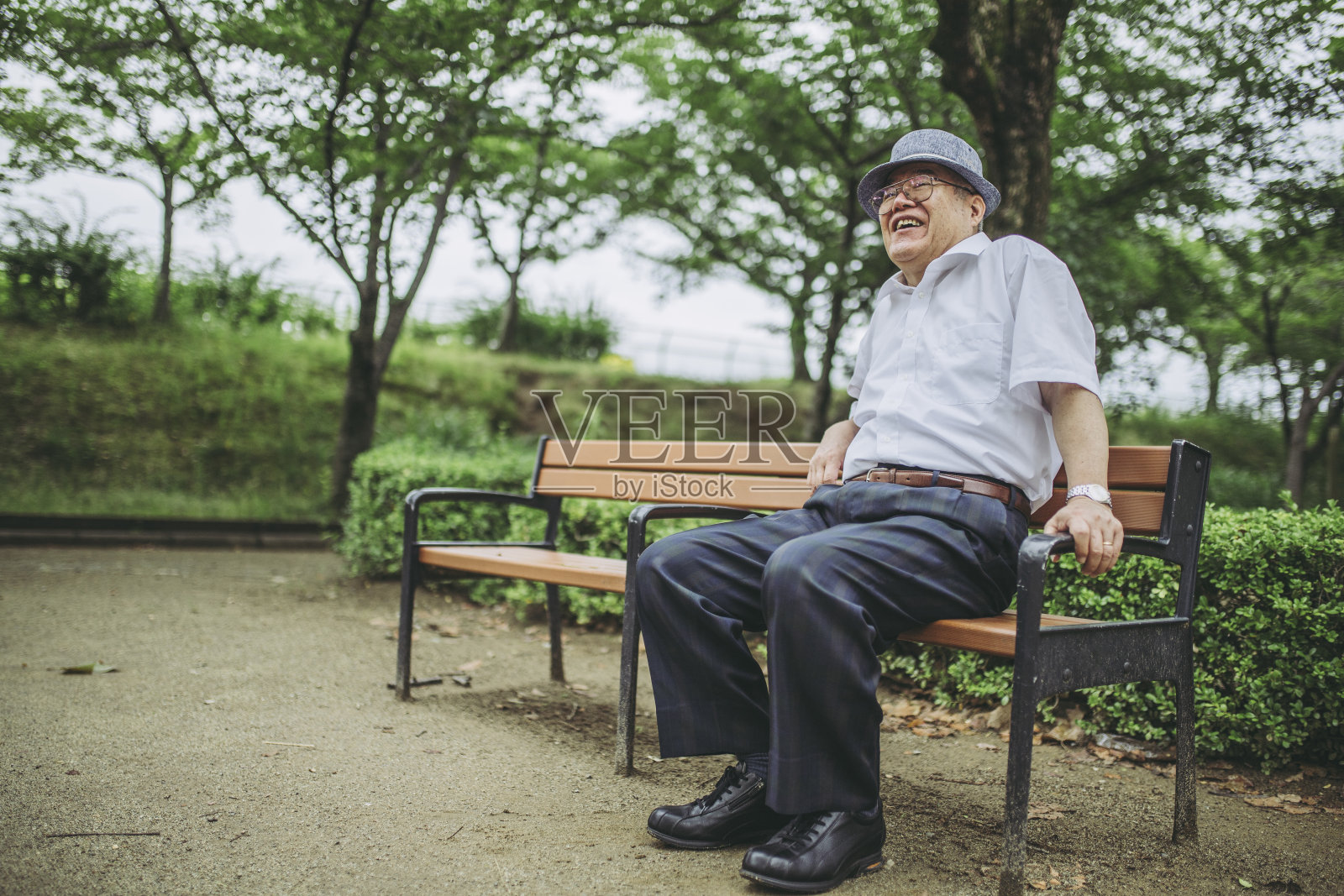 老人在公园长椅上休息照片摄影图片