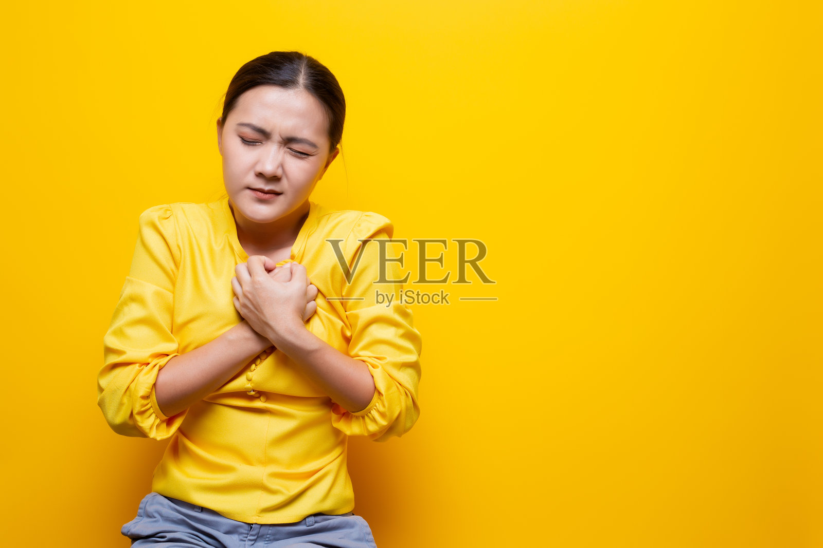 黄色背景上有胸痛照片摄影图片
