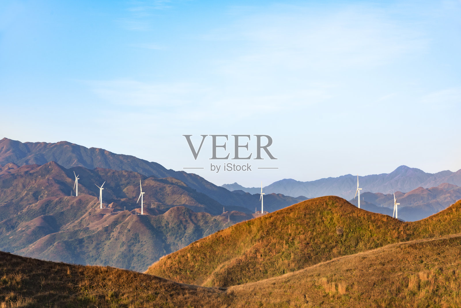 山上的风力涡轮机在日出和日落在云海照片摄影图片