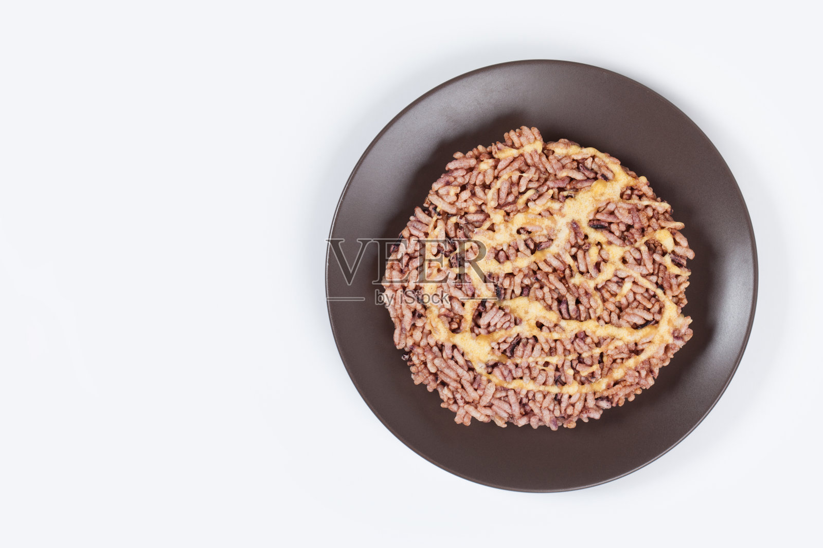 年糕是一种年糕名圆而扁的甜肉，是泰国的一种甜点，放在棕色的盘子上，白底孤立。照片摄影图片