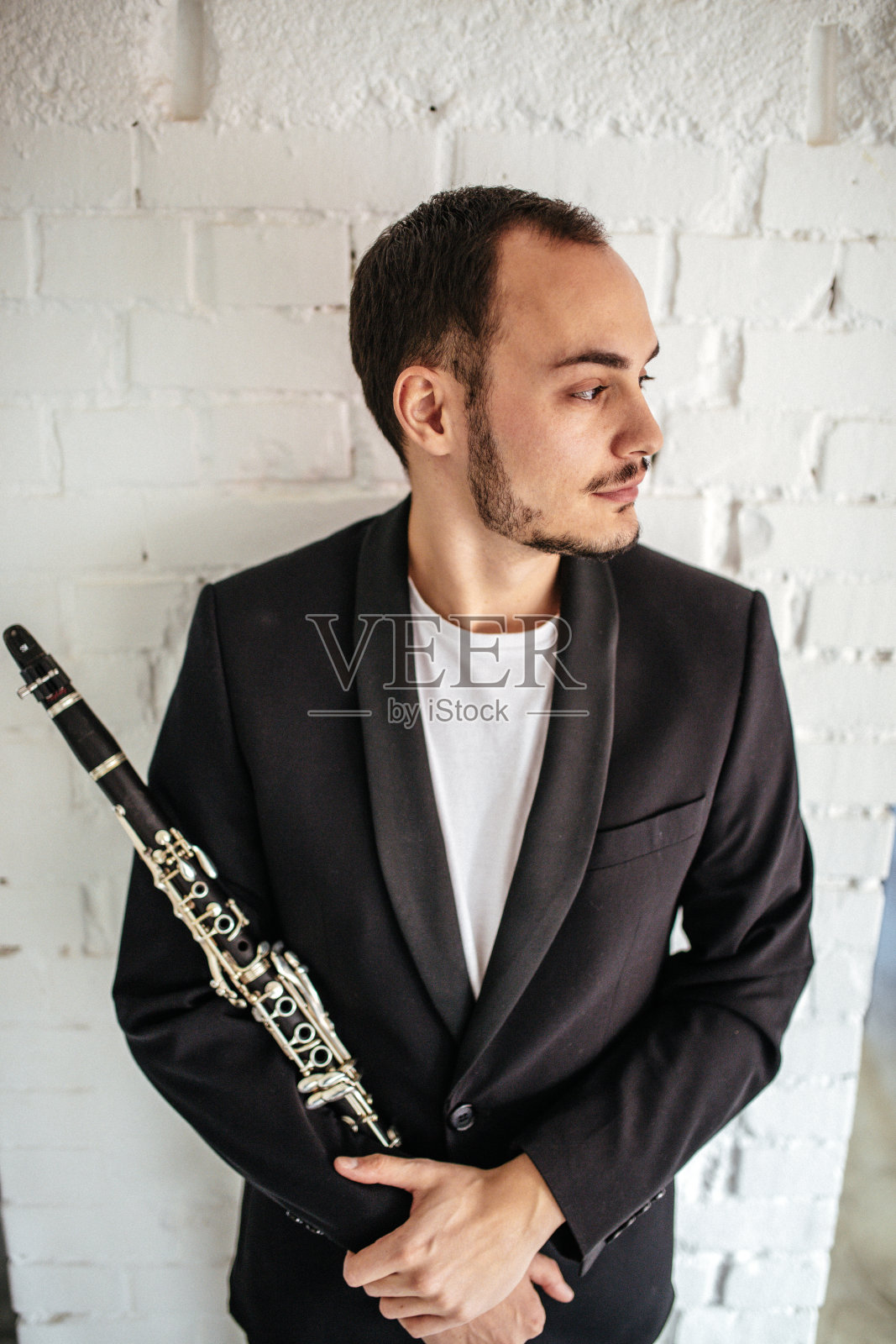 英俊的年轻人拿着单簧管照片摄影图片