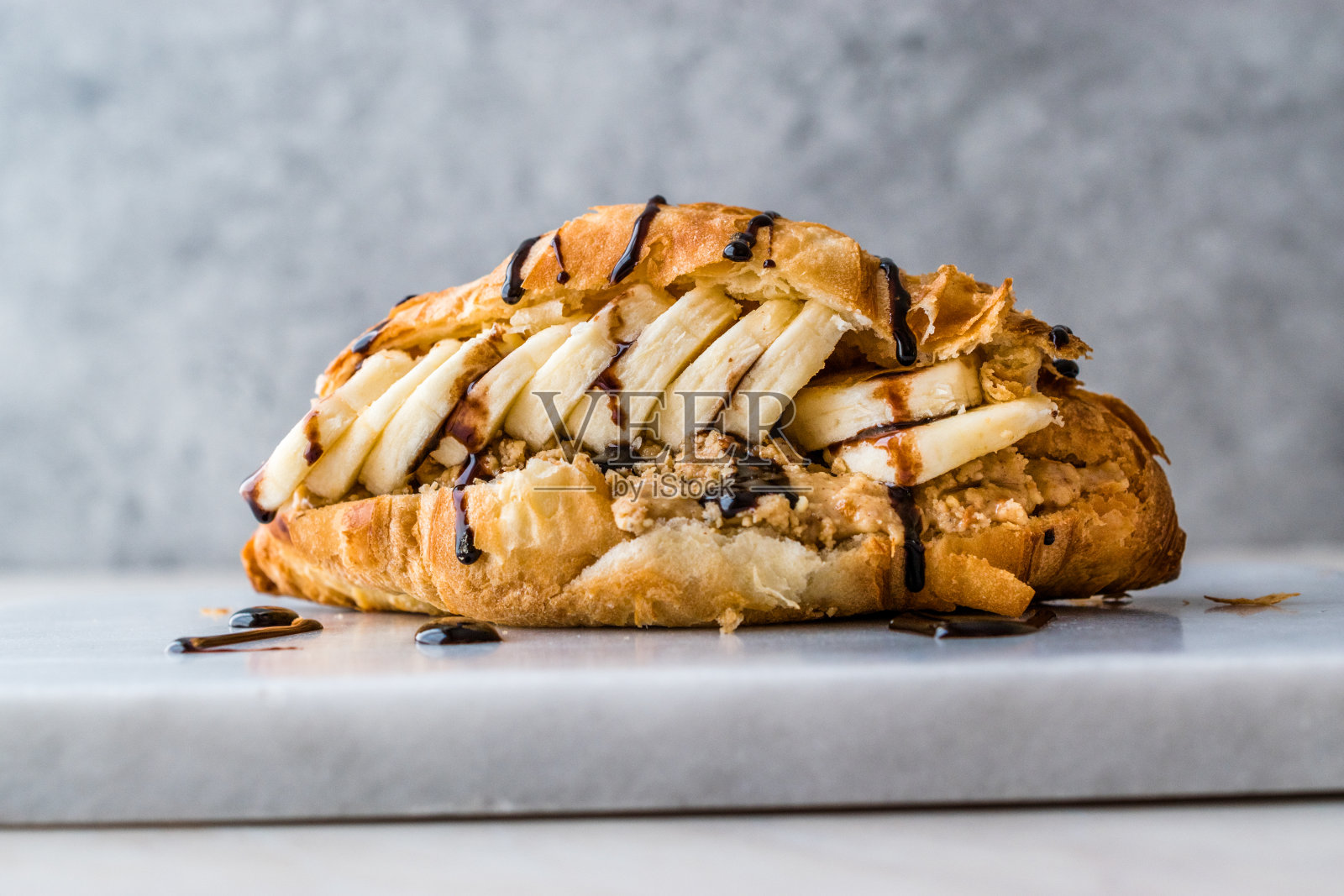 牛角面包三明治配香蕉、花生酱和巧克力酱。照片摄影图片