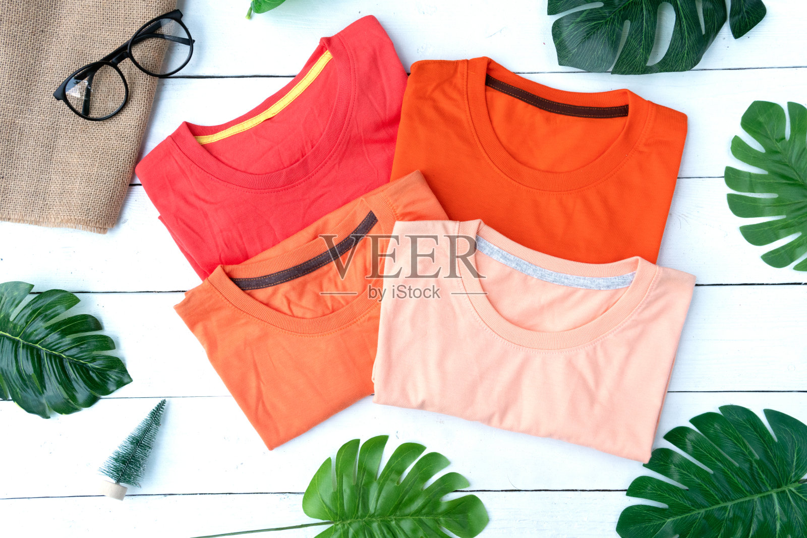 复古折叠橙色棉t恤衣服彩色模拟模板在垃圾白色木材背景概念零售服装店背景，空白平铺复古灰色木制朴素的洗衣广告照片摄影图片