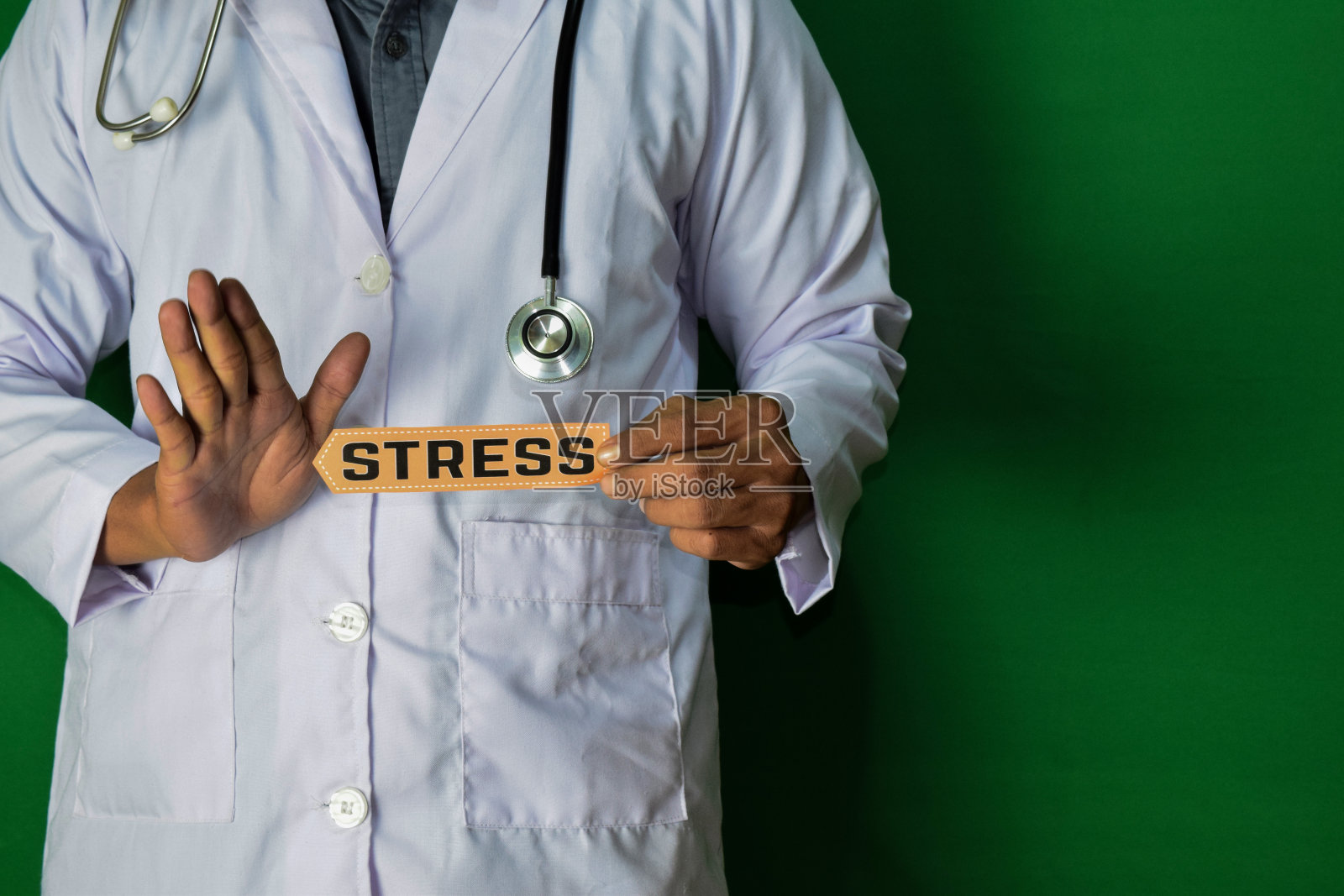 一个医生站着，按住压力纸上的文字绿色背景。照片摄影图片