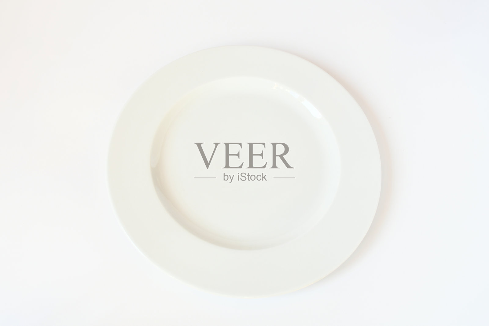 顶视图空干净圆白色盘子上的白色背景，物体为放食物水果和甜点。照片摄影图片