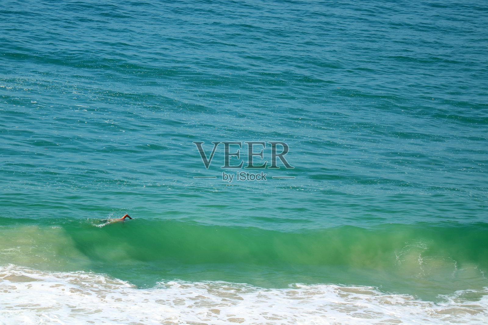 在巴西里约热内卢的科帕卡巴纳海滩，一名男子在大西洋的大浪中游泳照片摄影图片