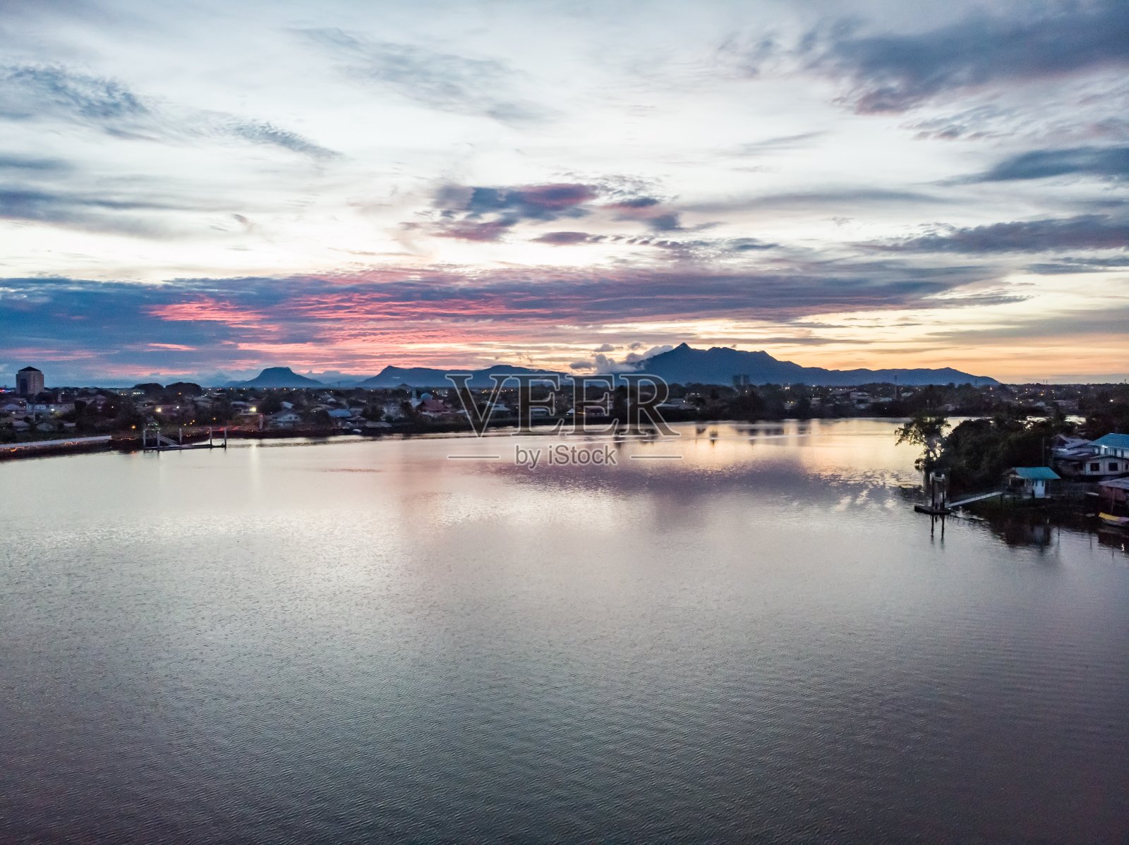 夕阳下的马来西亚古晋沙捞越河，背景是塞拉比山照片摄影图片