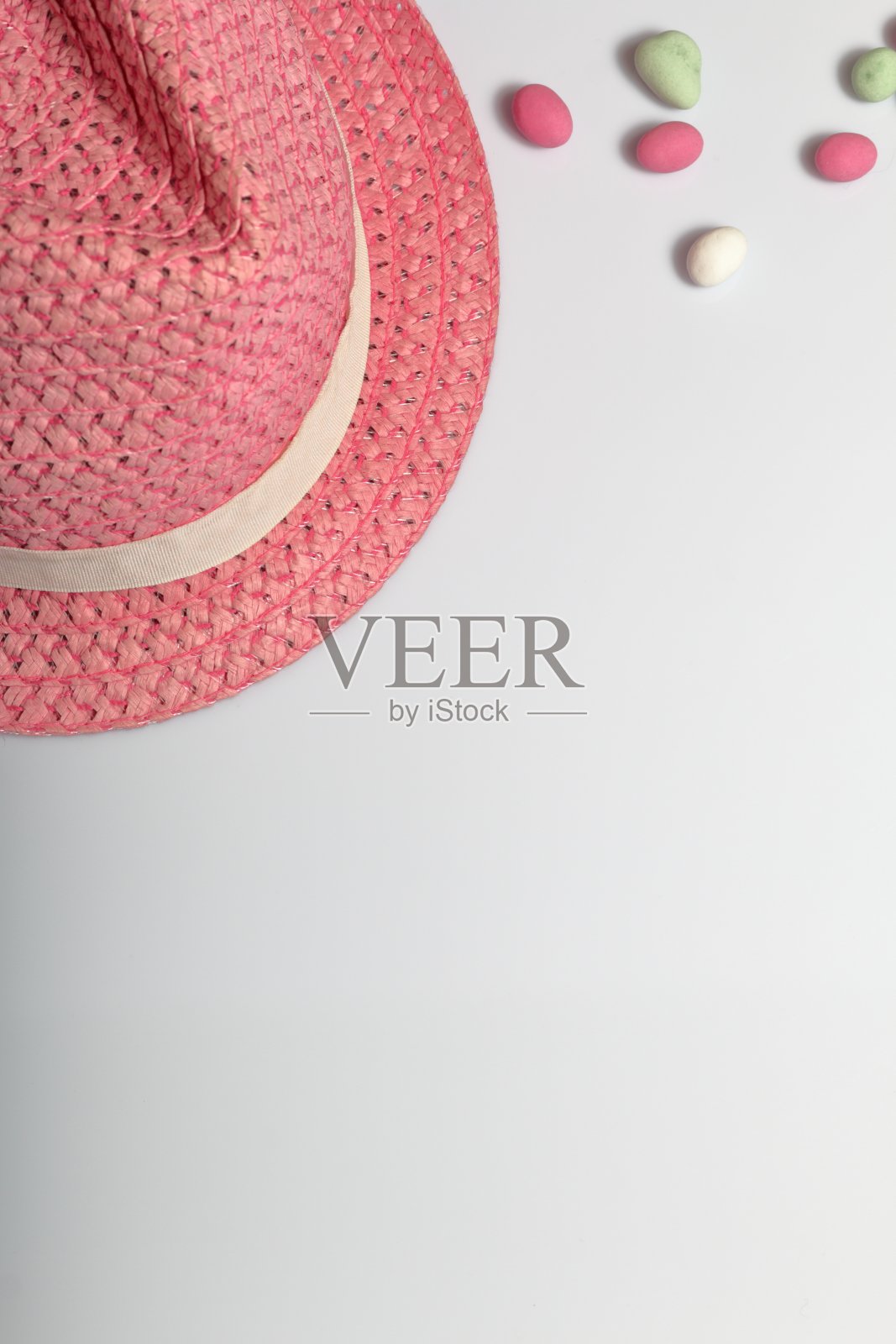 暑假配件。太阳的帽子。附近是白色背景上的彩色鹅卵石。照片摄影图片