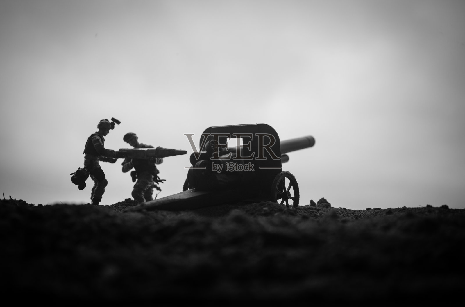 战斗场景。老野战炮的剪影站在战场上准备开火。有彩色的深色雾背景。有选择性的重点照片摄影图片