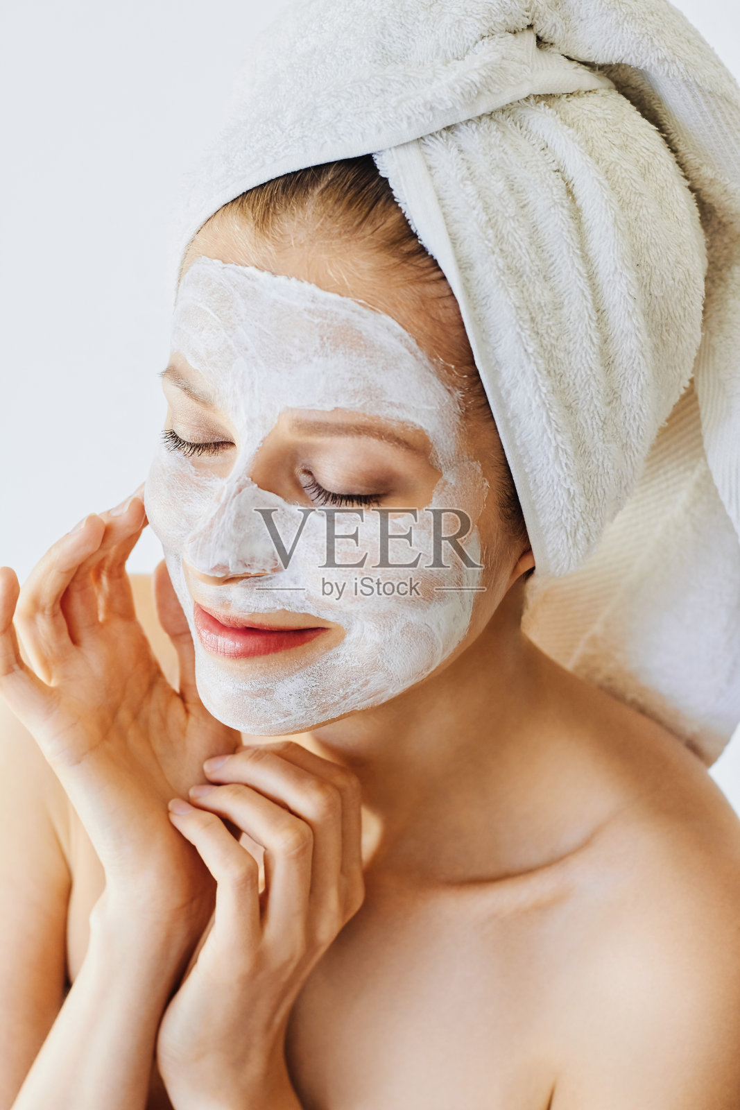美丽的年轻女子，脸上戴着面膜照片摄影图片