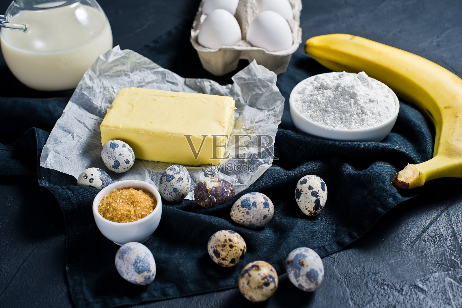 烹饪香蕉面包的概念。配料:香蕉、黄油、鹌鹑蛋、糖、面粉、牛奶。黑色背景，俯视图。照片摄影图片