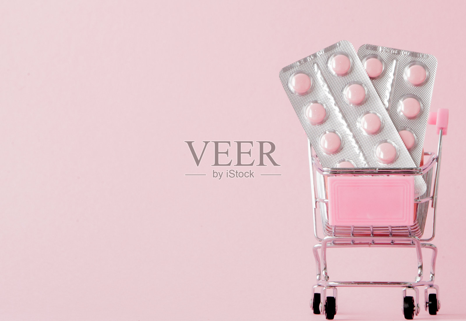 购物手推车与药品在粉红色的背景与副本空间照片摄影图片